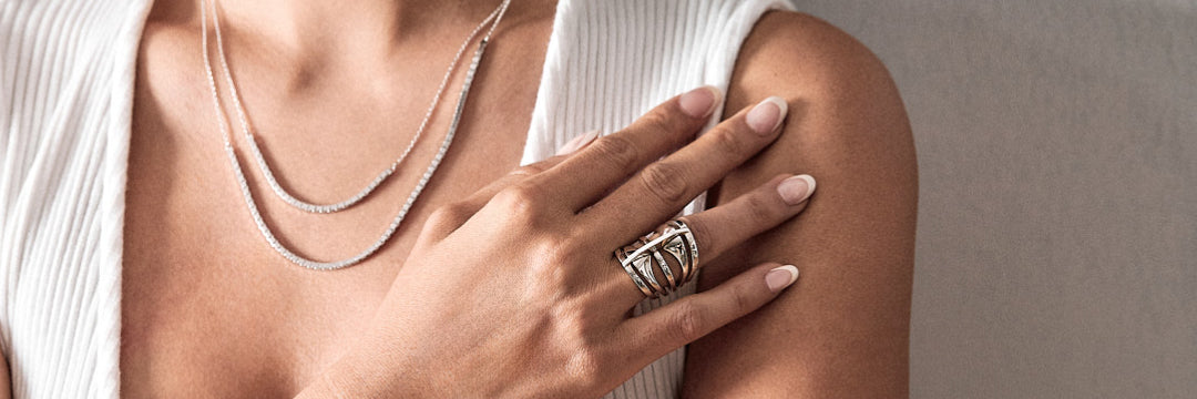 woman wearing halo necklace and halo luna necklace in 18K gold also wearing a custom engagement ring.