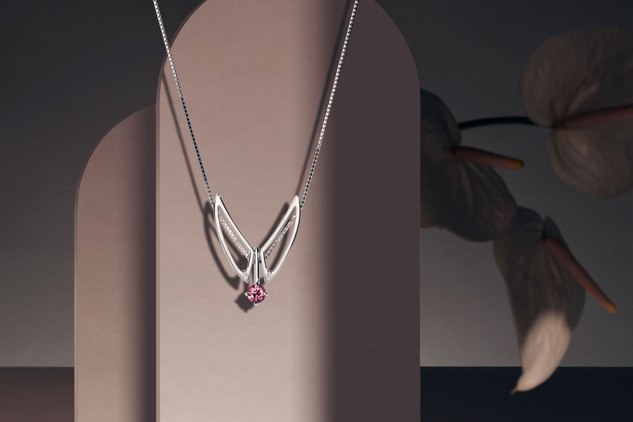 All Semi Fine Jewelry collection showcasing an elegant sterling silver necklace with a garnet ring. This adjustable sterling silver necklace can be worn short or long.