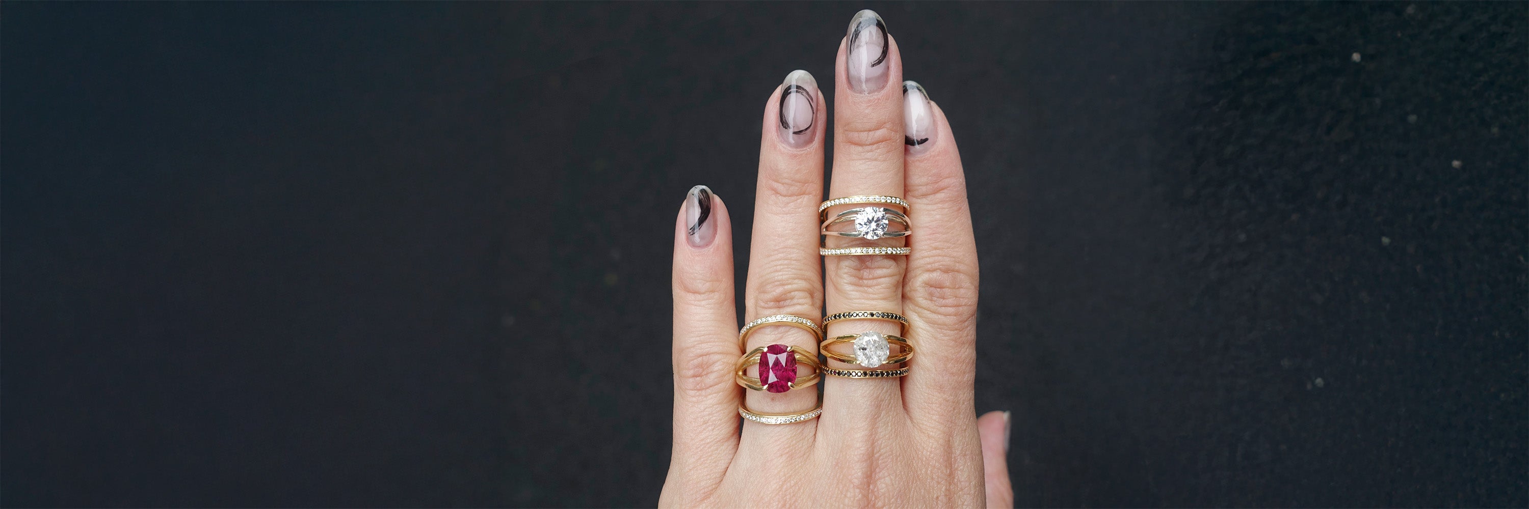 Close-up of interlocking wedding rings featuring a prominent red gem and elegant gold design, showcasing a modern and artistic touch perfect for couples.