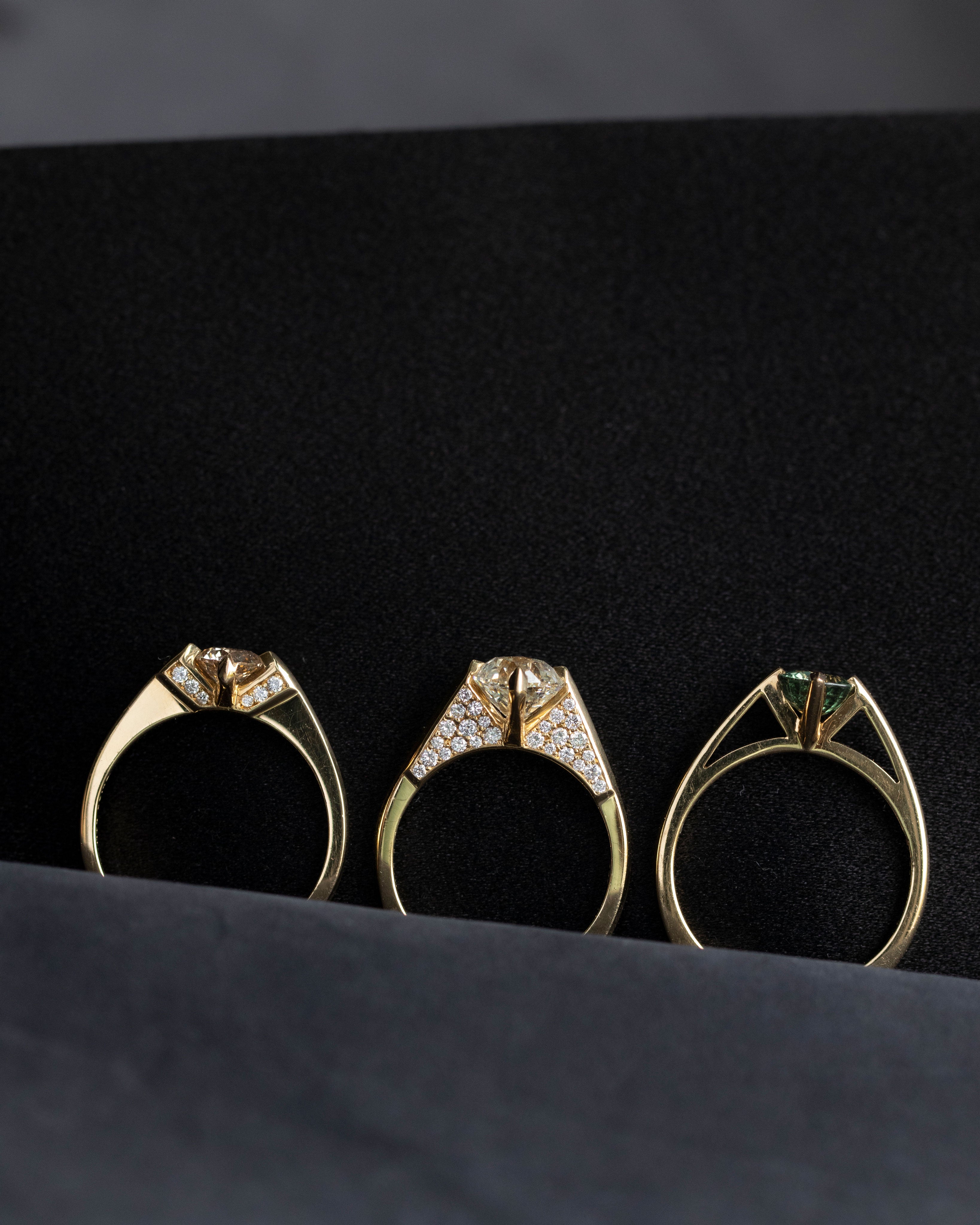 Three luxurious minimalist gold rings displayed elegantly, each representing a variation: minimalist arc, minimalist rise, and minimalist pave from Bliss Lau.