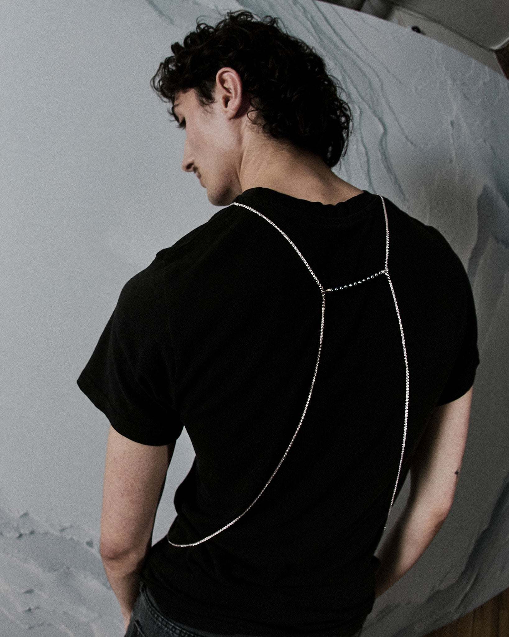 Limited Edition Tuxedo Black Bodychain showcasing a sleek design on a model's back, highlighting adjustable sterling silver cable and elegant lines that enhance body contours.