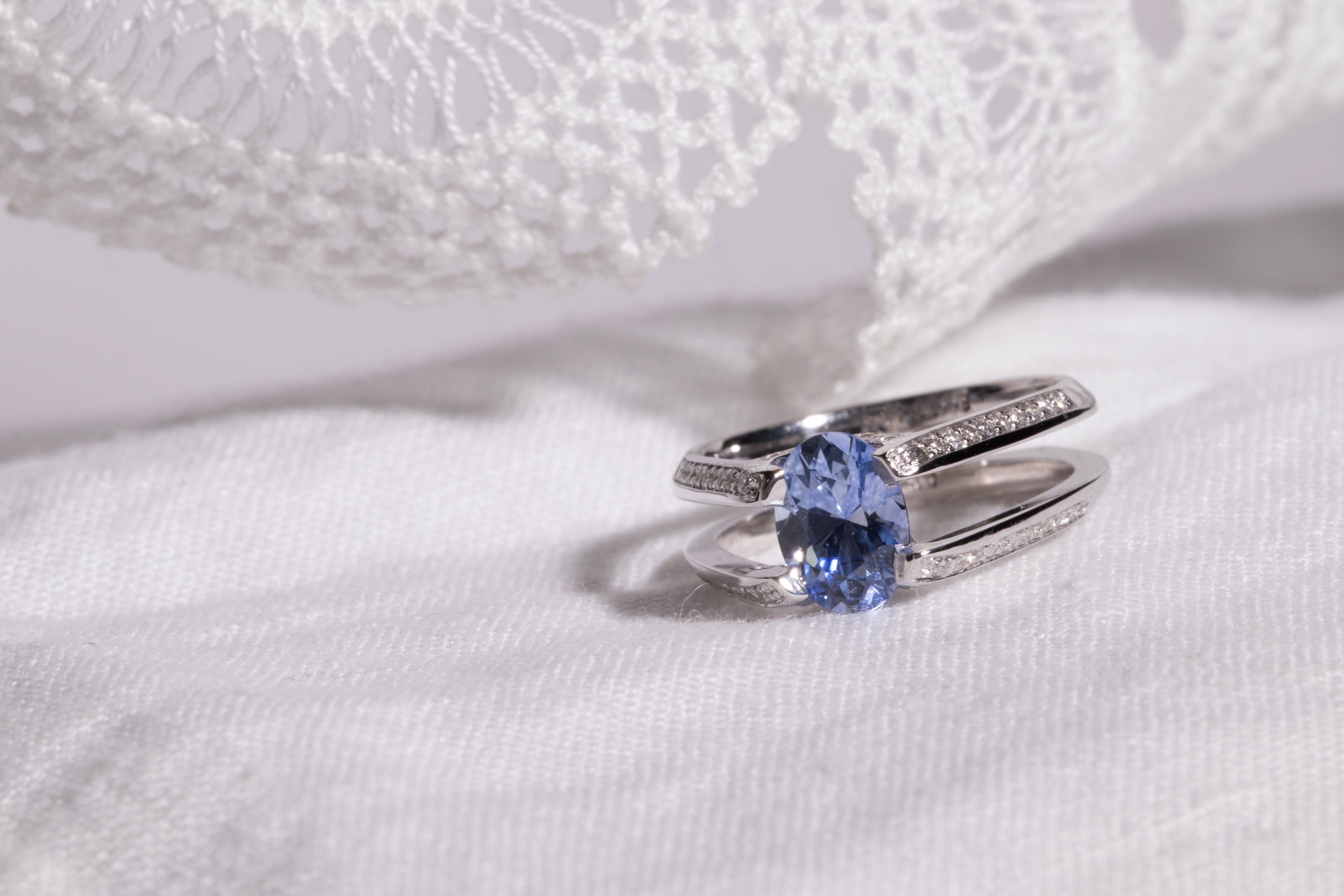 Futurist Engagement Ring Signature Collection showcasing a stunning oval blue gemstone set in a sleek double band, accented with pave set white diamonds, exuding elegance and luxury.