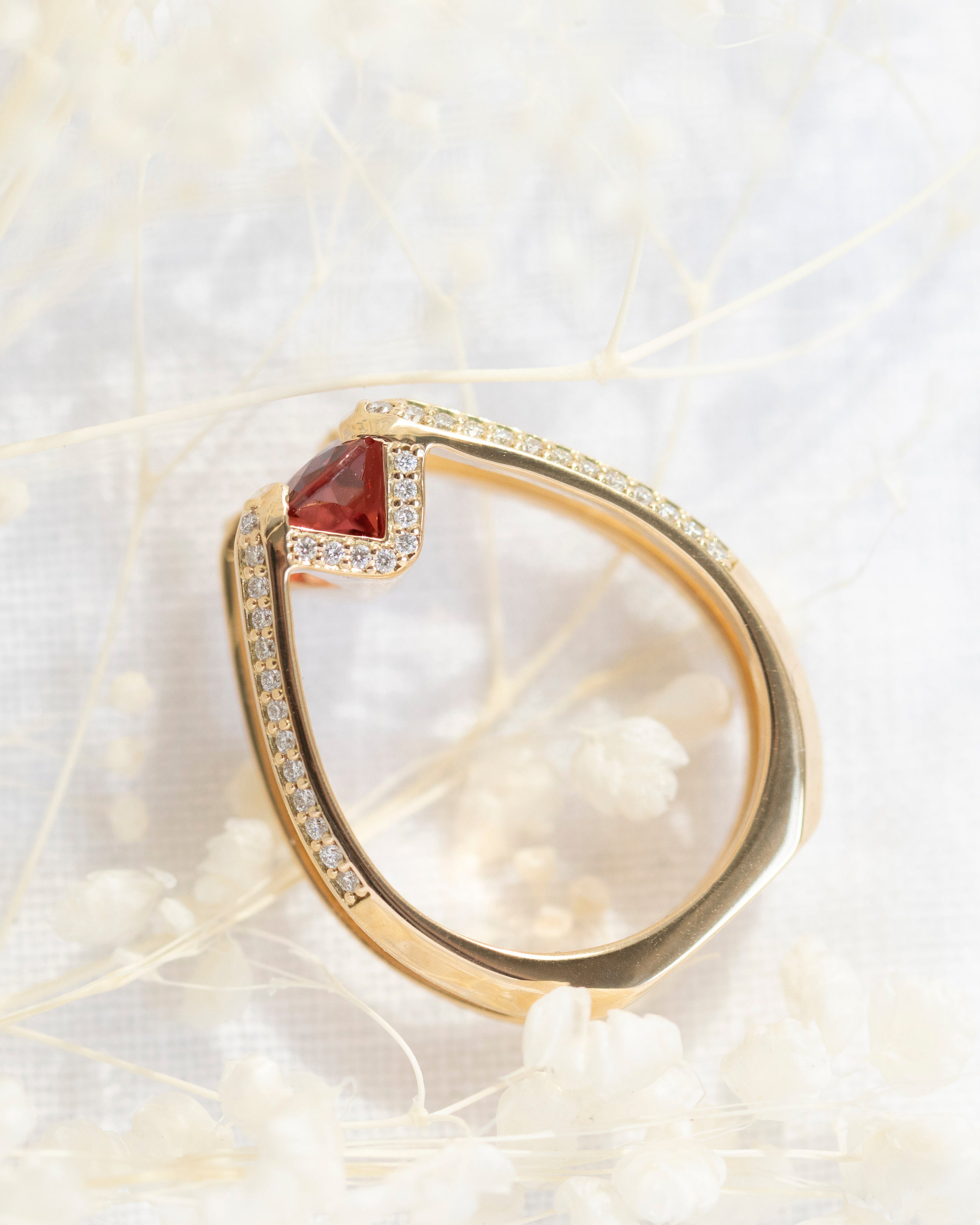 Futurist Engagement Ring Signature Collection featuring a stunning gold ring with a unique design, showcasing a red gemstone and exquisite white diamond pave setting, ideal for luxury engagements.