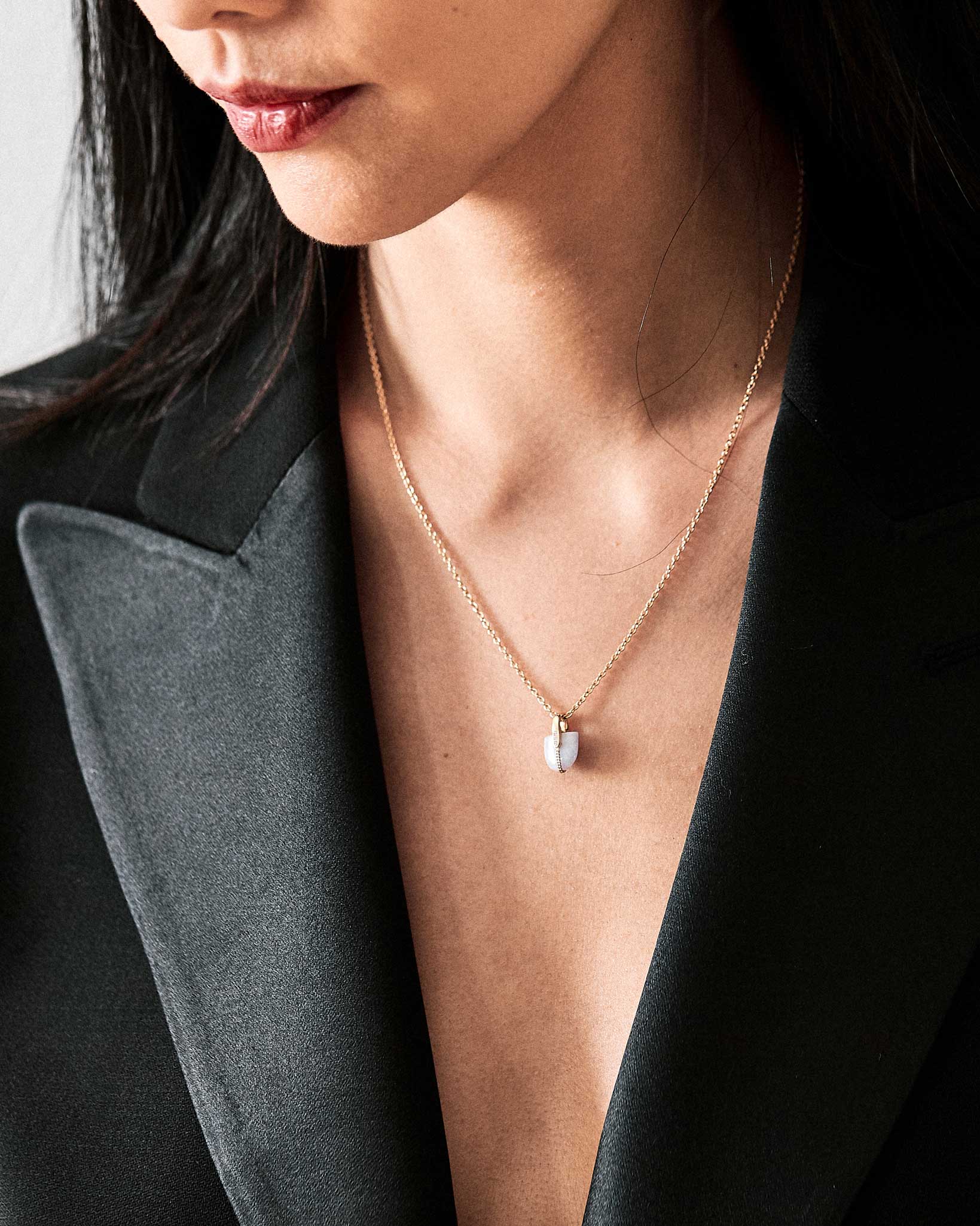 Close up on chest of model wearing platinum necklace with lavender jade pendant
