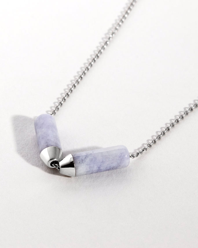Close up of platinum N=necklace with lavender jade pendant on a white background