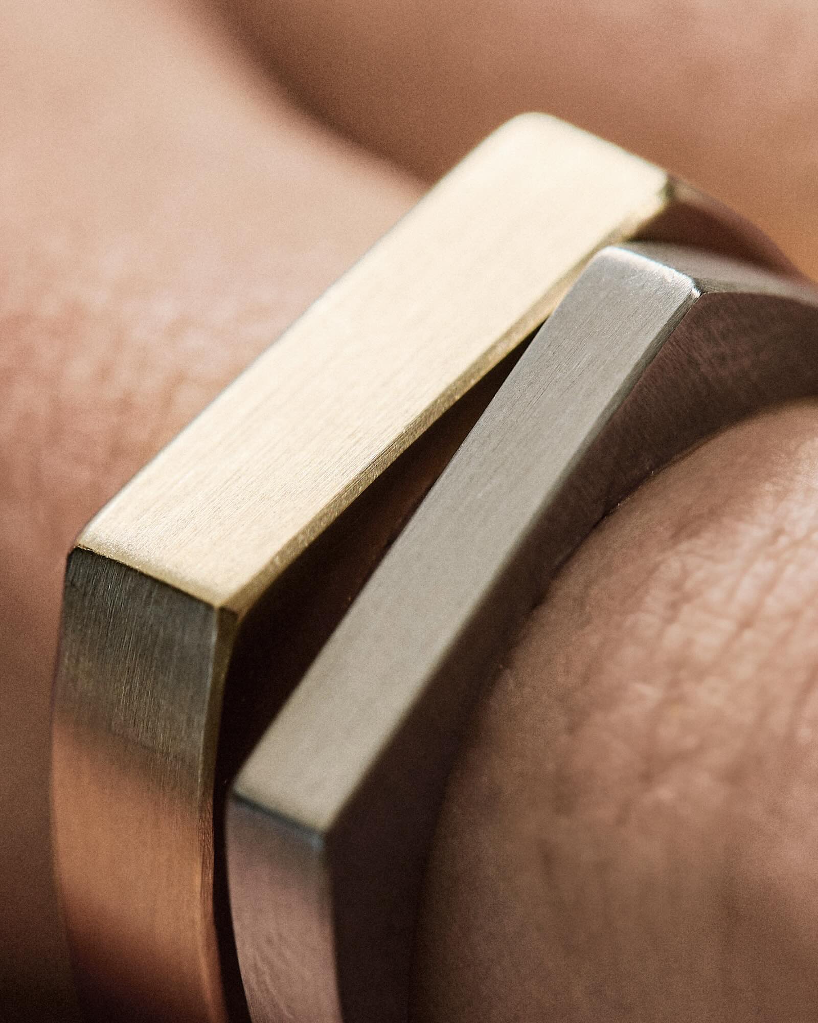 two mens gold wedding bands on a finger