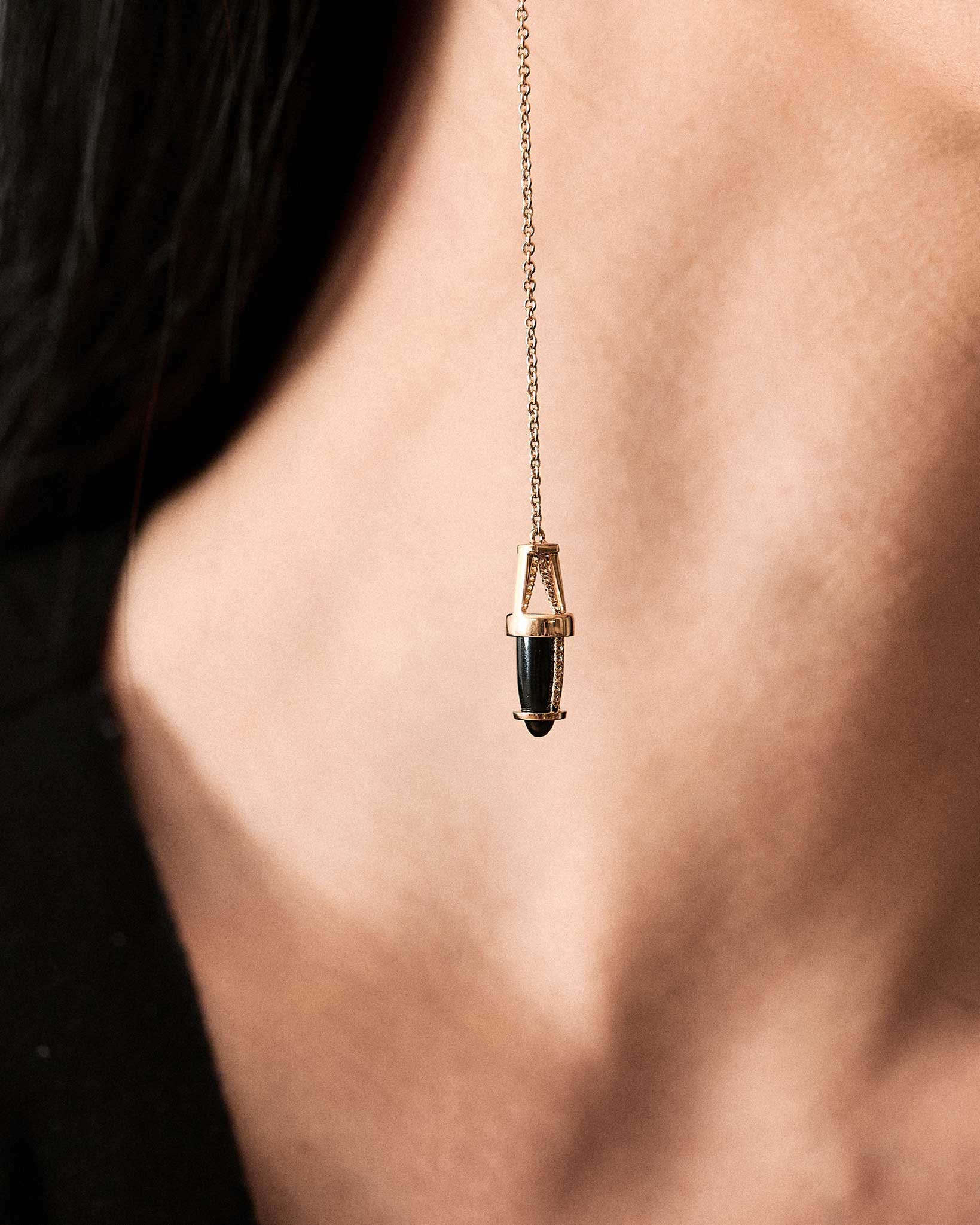 Close-up of The Vantage Curio Black Jade pendant worn on a model's neck, showcasing the exquisite black jade and gold design by Bliss Lau.