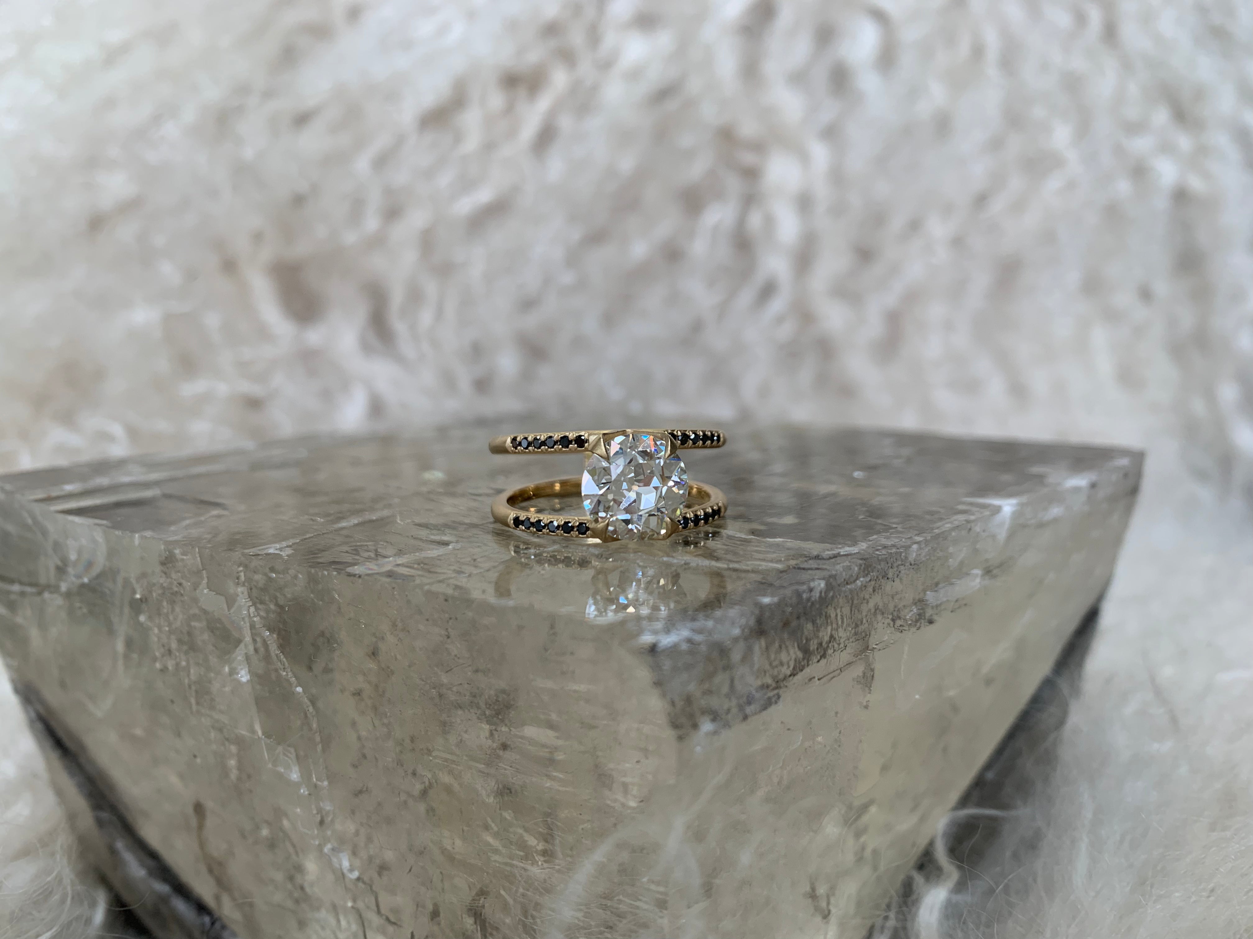 Illuminate Engagement Ring from Signature Collection showcased on a crystal pedestal, featuring a brilliant center stone and minimalist band, perfect for an active lifestyle.