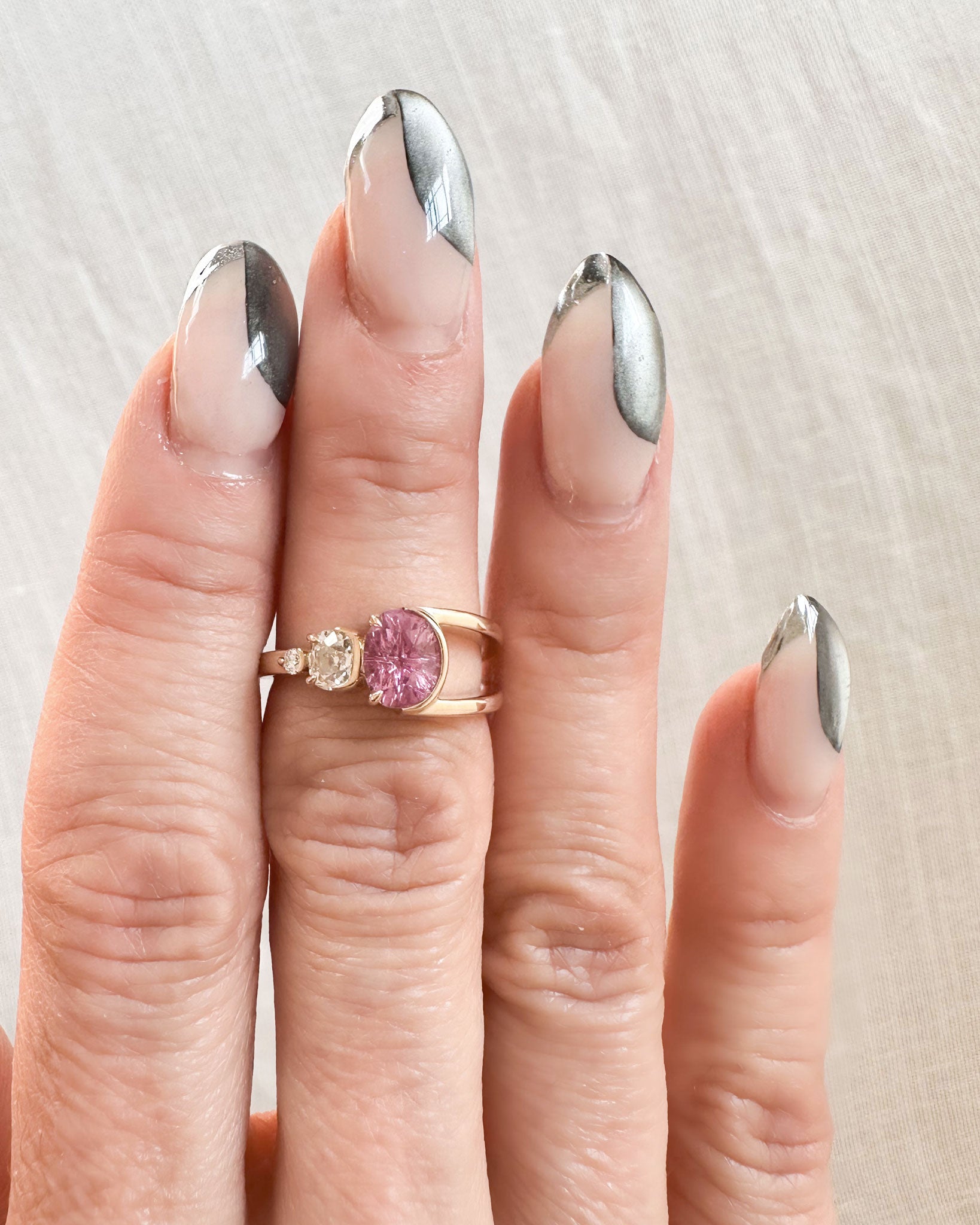 Glamorous Bright Ring Pink Sapphire worn on a hand with stylish nails, beautifully showcasing the pink sapphire and diamond combination in a modern setting.