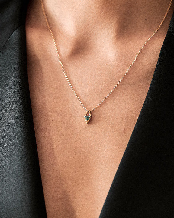 Close-up view of the Reflection Necklace Emerald highlighting its stunning design and craftsmanship, set on a delicate 18k yellow gold chain.