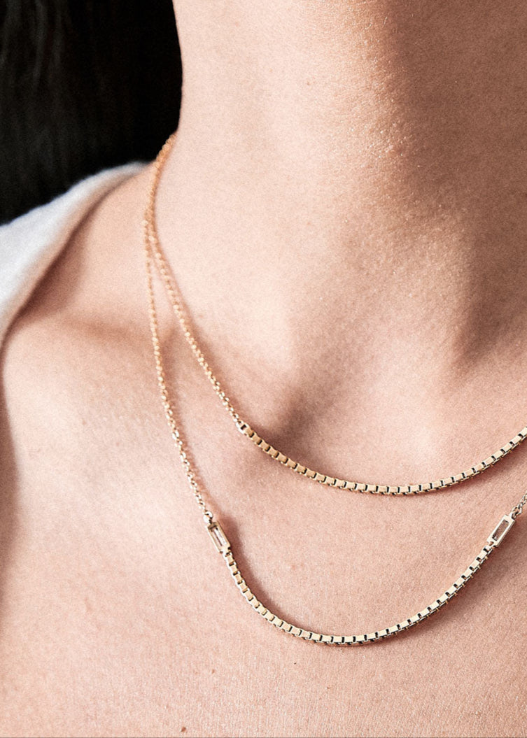 Elegantly draped Halo Necklace featured on a model's neck, showcasing its luxurious design in 18k yellow gold.