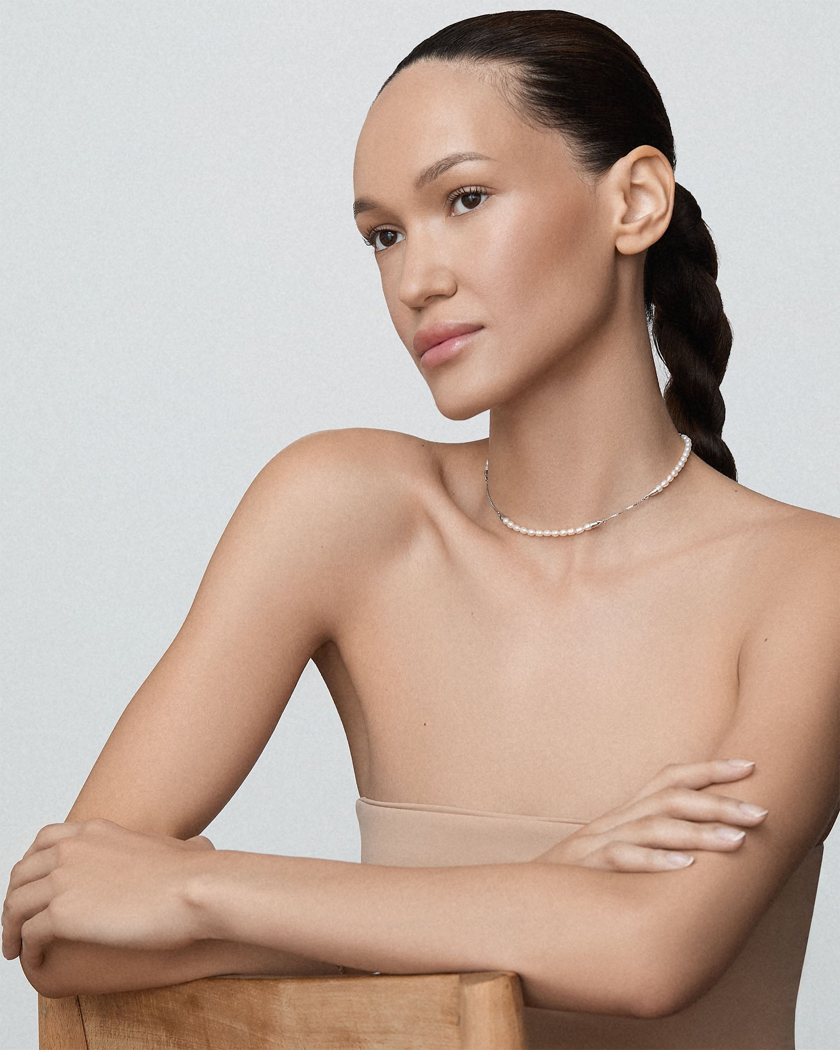 Bliss Lau Meridian necklace freshwater pearl necklace sterling silver on woman on a grey background.