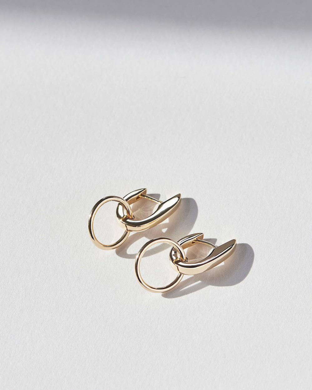 Pair of gold hoop earrings on a light gray background