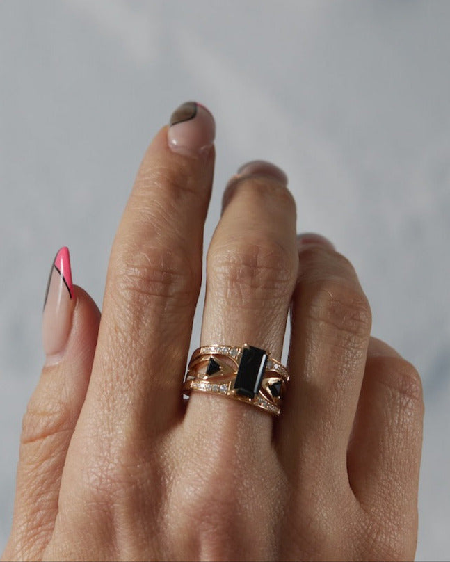 Lifestyle shot of the Mirage + Reflection Ring Set worn on a hand, featuring black spinel and 18K yellow gold by Bliss Lau.