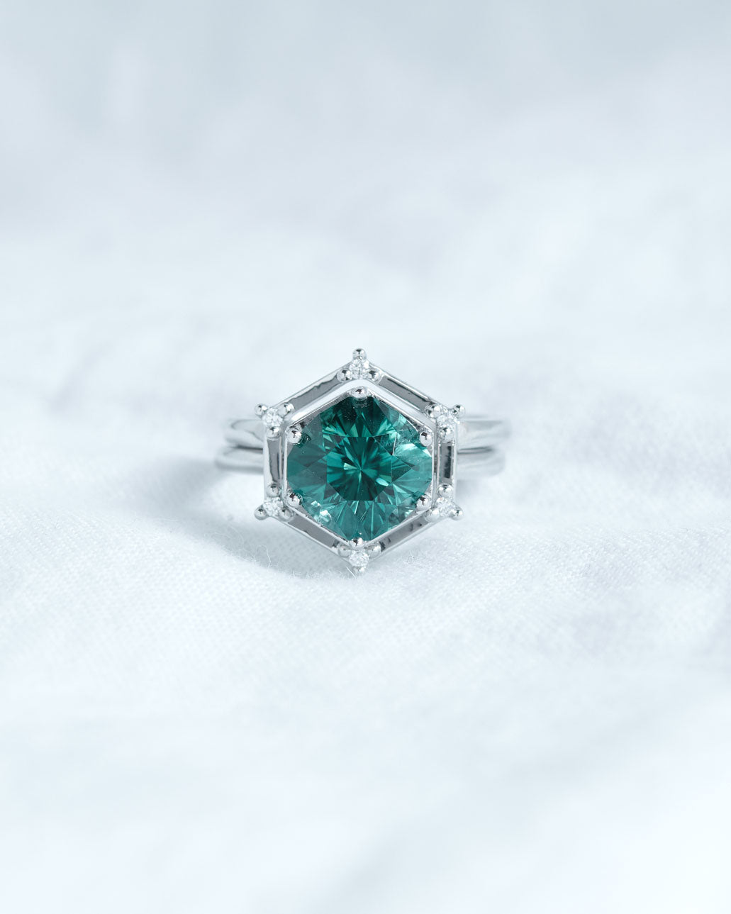 Aura Ring Wedding Ring Set featuring a stunning hexagonal teal gemstone surrounded by shimmering diamonds, exquisitely crafted in white gold.