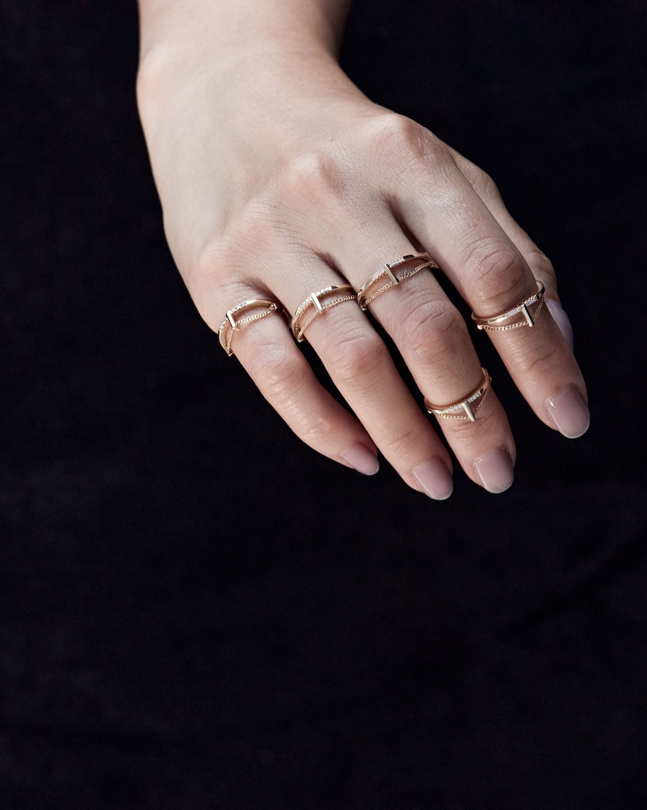 An artistic view of a hand featuring several Pave Cusp Rings 18K, illustrating the harmonious blend of elegance and modern design.