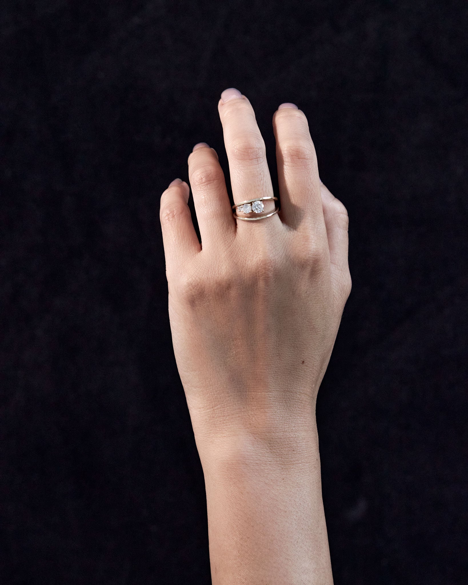 Empath Ring displayed on a hand against a dark background, showcasing its sparkling lab diamonds and sophisticated design.
