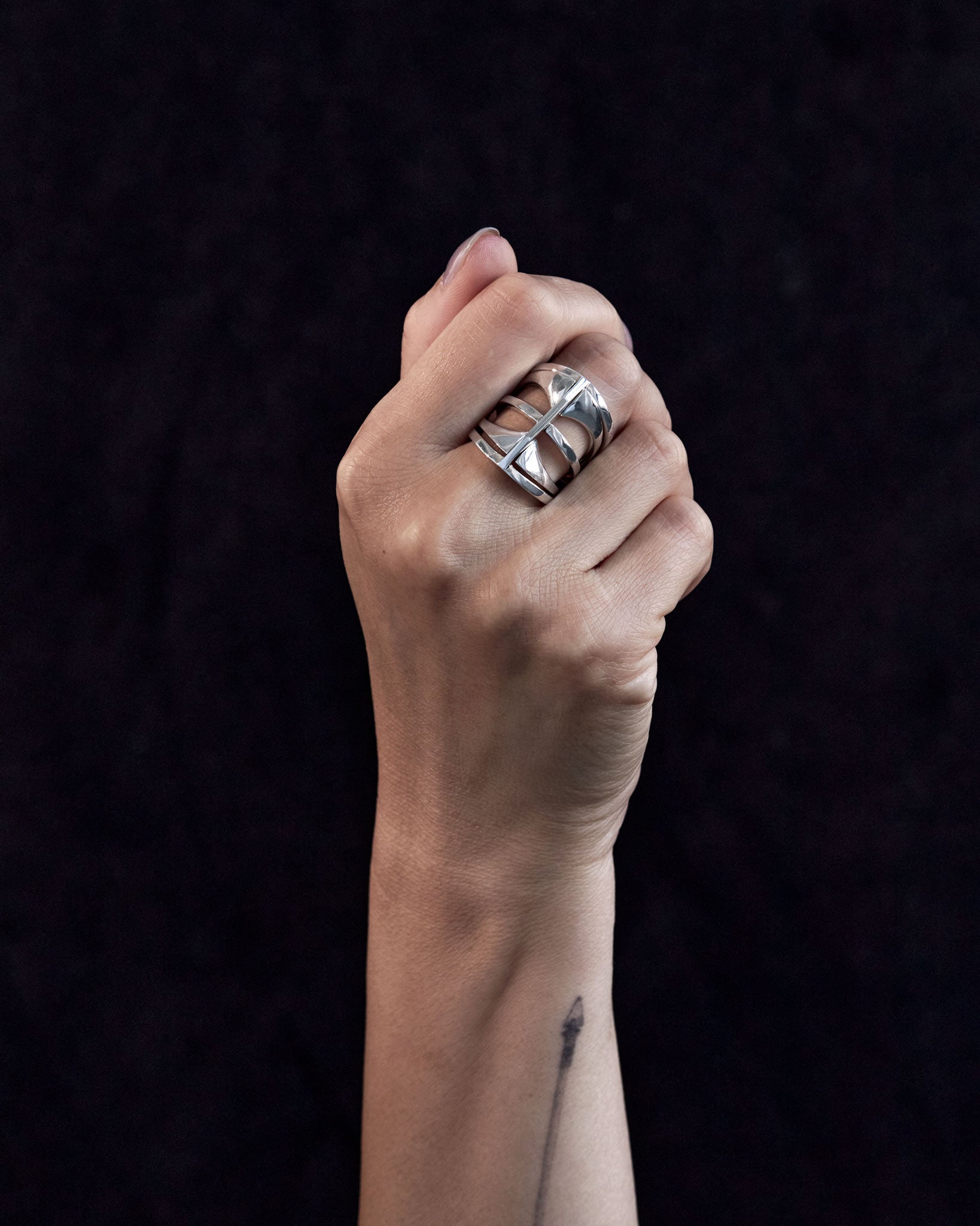 Hand wearing multiple Kaleidoscope rings, illustrating the rings' fit and style in sterling silver against a neutral backdrop.