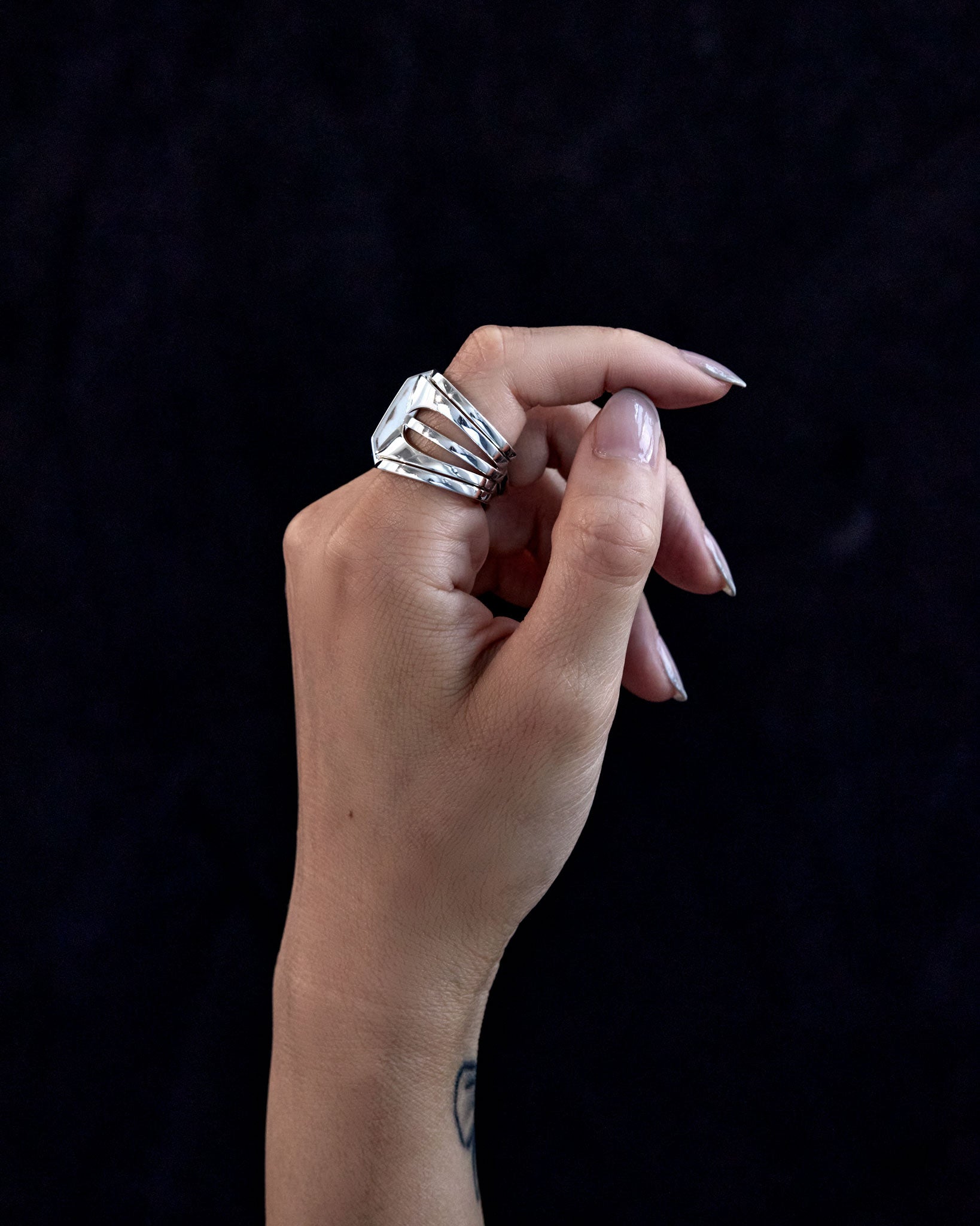 Hand holding the Kaleidoscope ring set, showcasing the rings' modern design and ergonomic fit on the fingers.