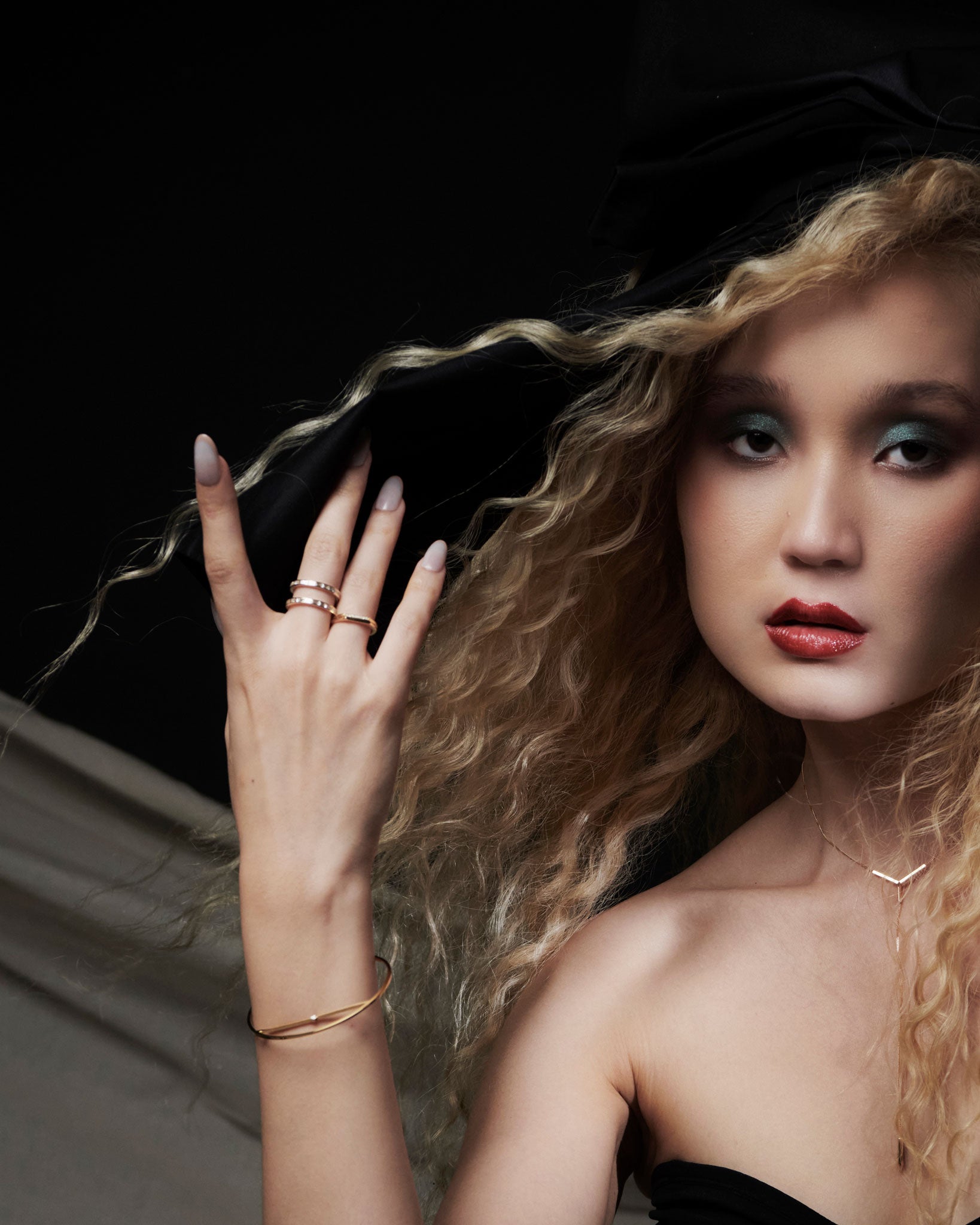 Model wearing Cascade II Enclose Ring with elegant hairstyle, showcasing the ring's luxurious appeal alongside other fine jewelry pieces in an artistic and contemporary setting.