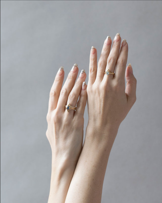 Two hands showcasing the stunning Spire Band alongside other rings, highlighting its versatility and luxurious appeal, perfect for any occasion.