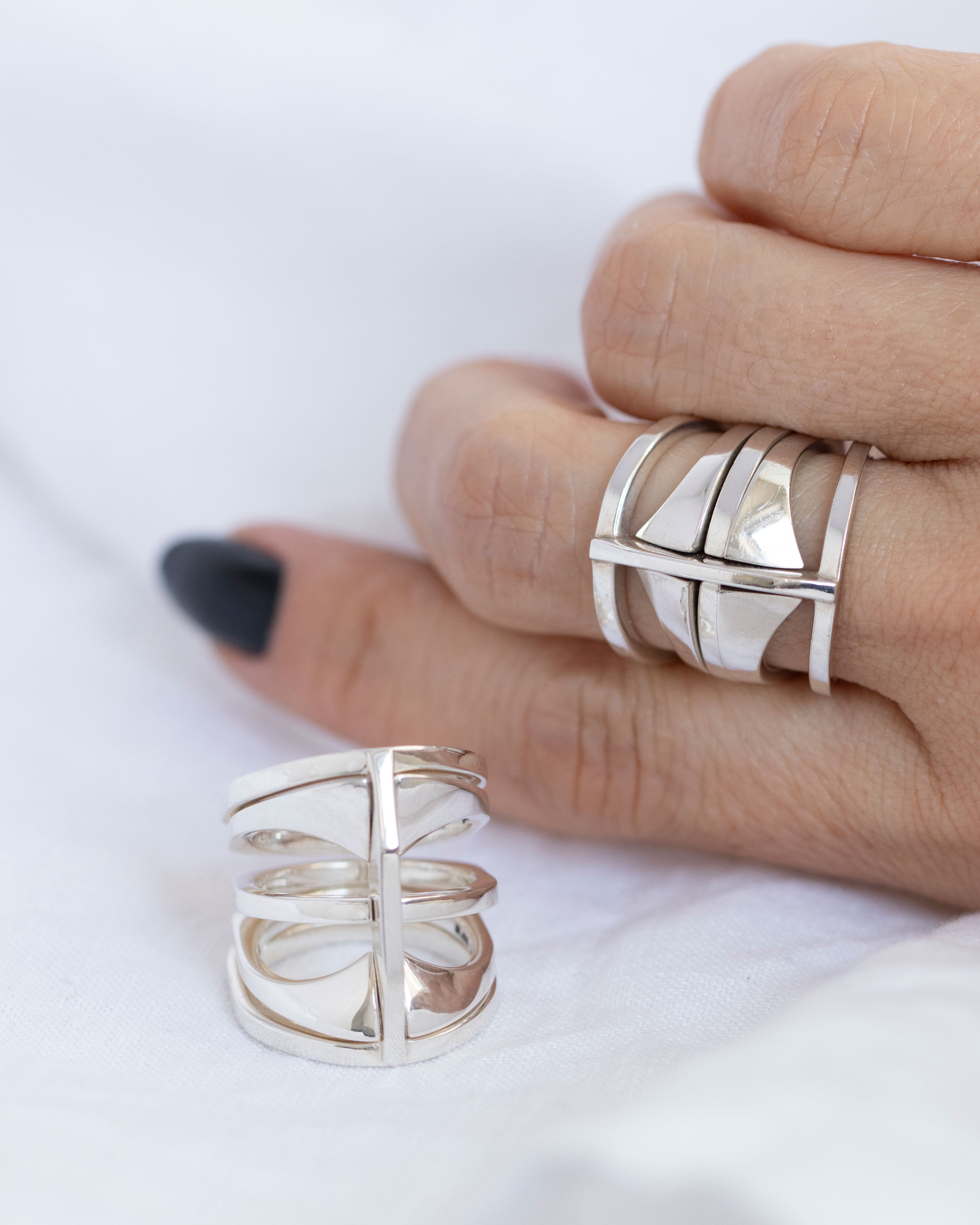 Fingers wearing different Kaleidoscope rings, demonstrating the versatile stacking options and stylish appeal of the silver jewelry.