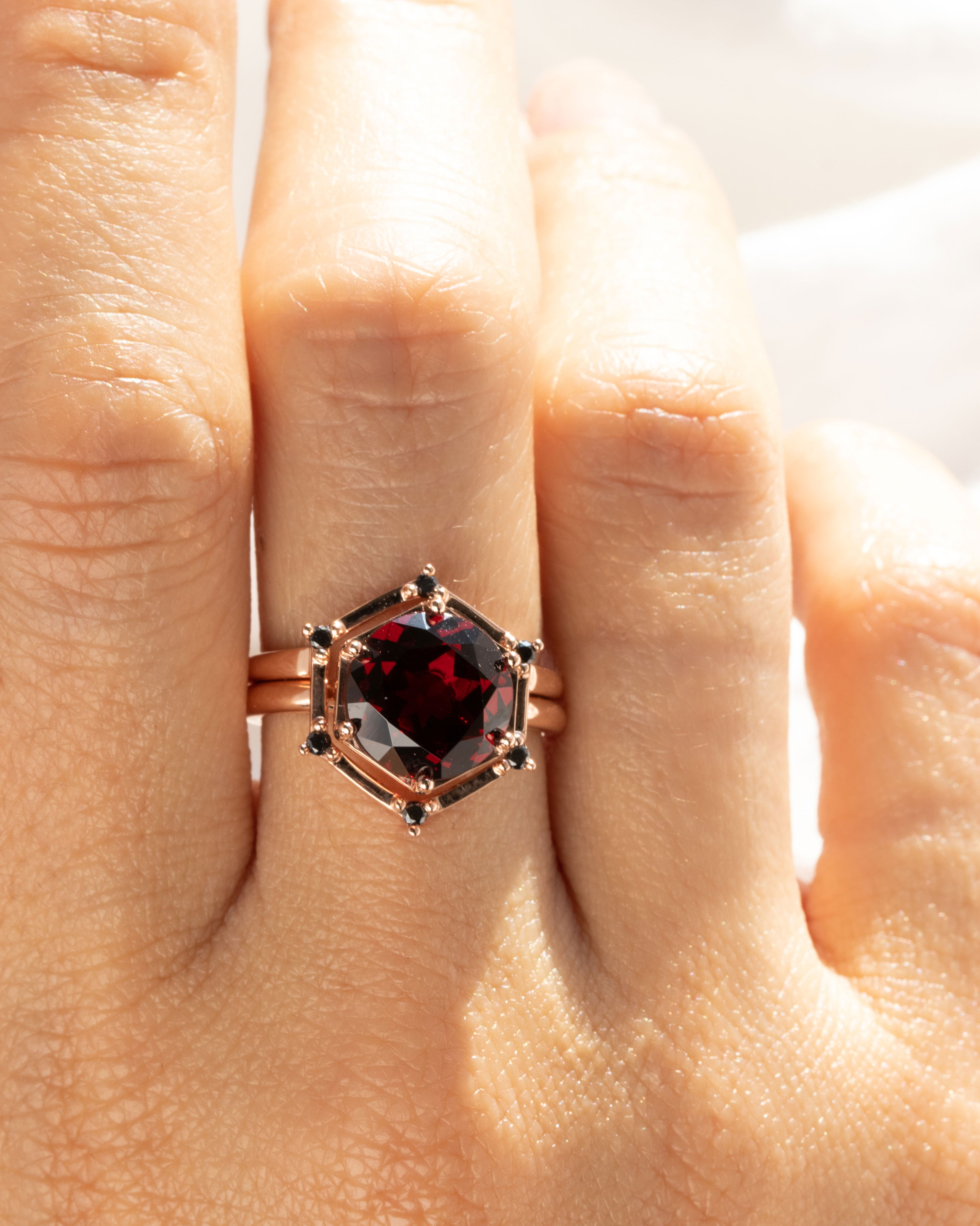 Aura Ring Wedding Ring Set featuring a stunning 4.85CT Round Red Garnet set in recycled gold, elegantly displayed on a hand to highlight its unique design and craftsmanship.