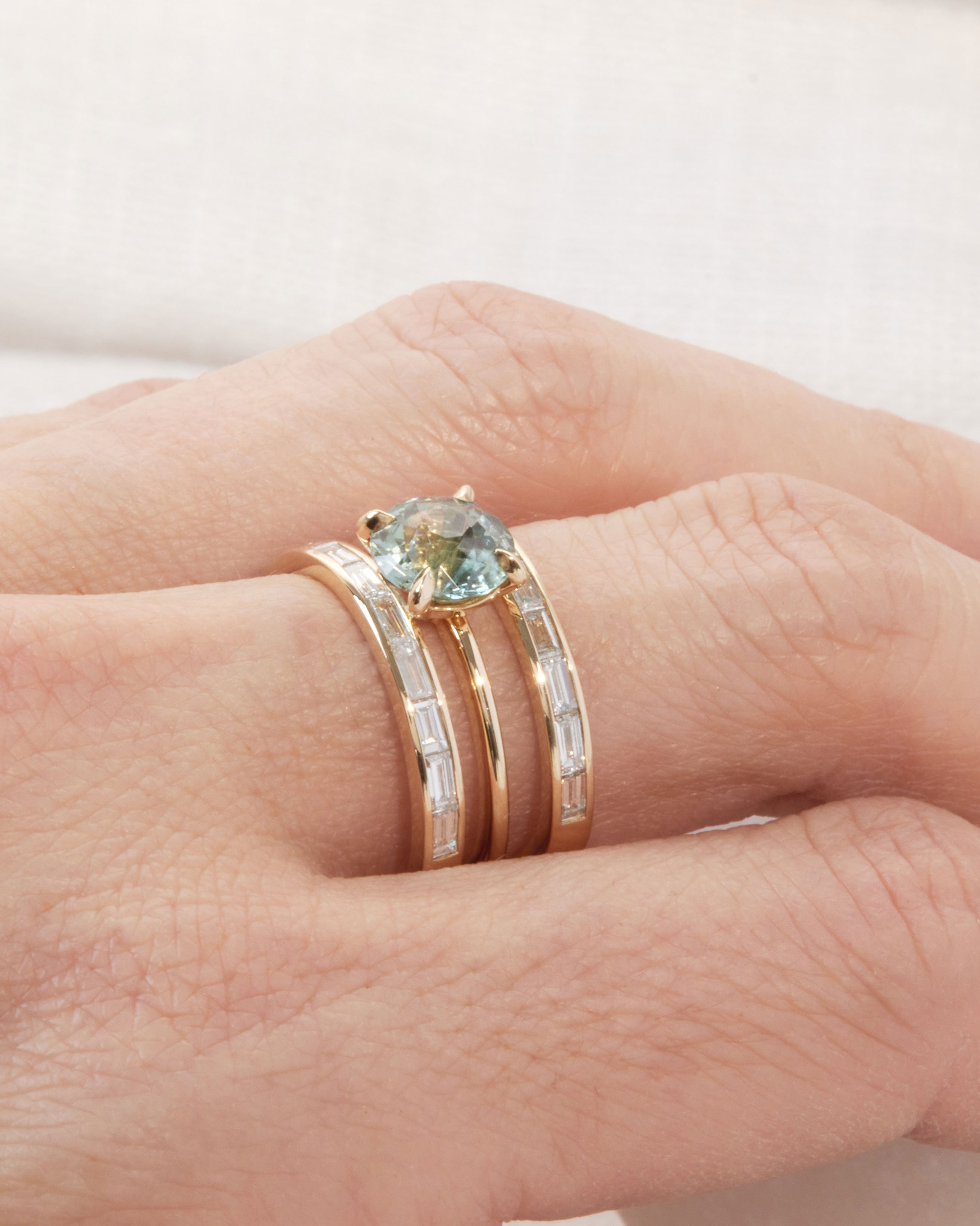 Different view of the Bliss Lau Poetic Engagement Ring and the Cascade II white diamond baguette wedding enclose band interlocking ring set.