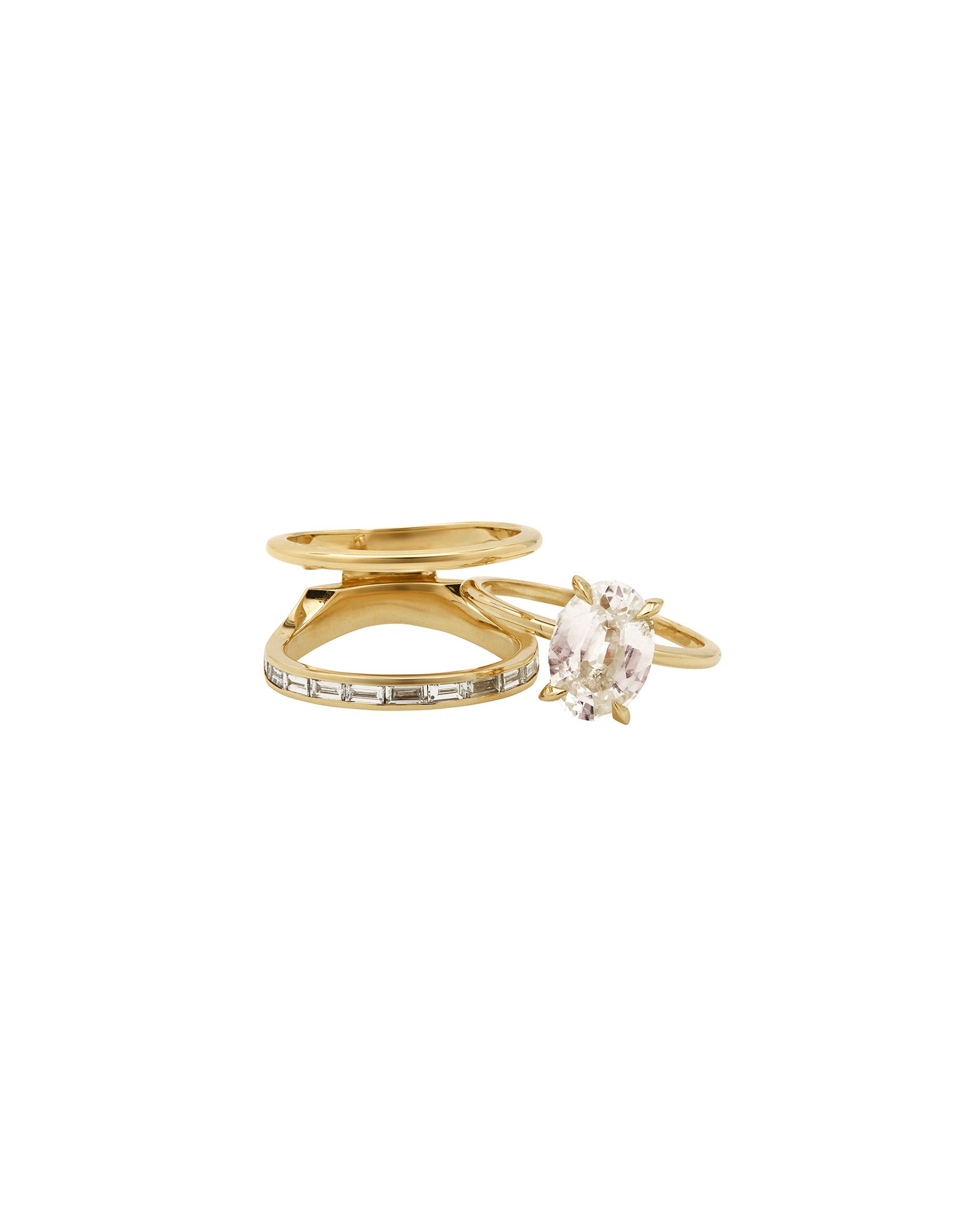 Poetic + Cascade Ring Set presented with a triple ring composition, showcasing a dazzling oval gem and sparkling diamond baguettes in a sophisticated gold aesthetic.