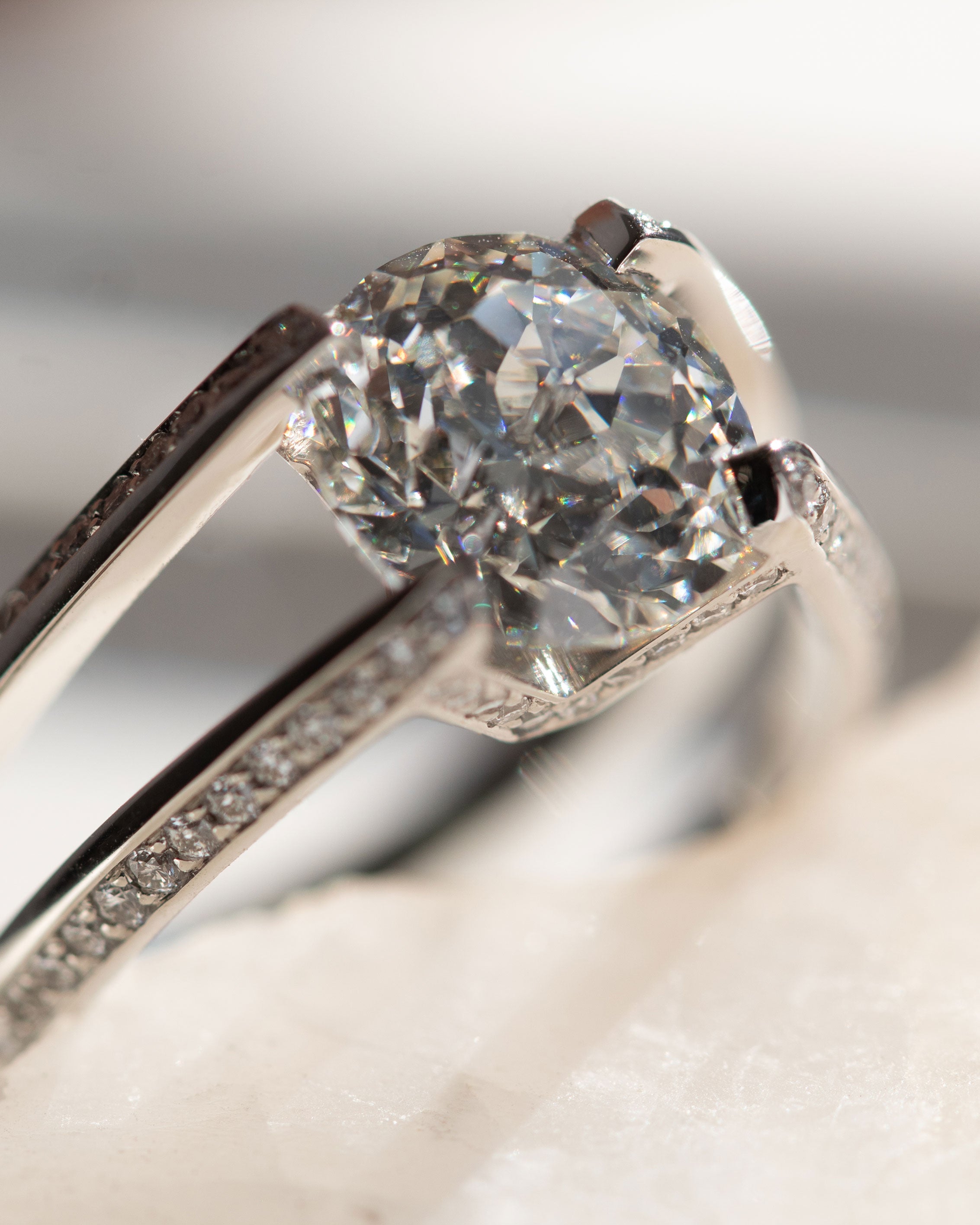 Close-up of the Futurist Engagement Ring Signature Collection highlighting the intricate details of the round diamond and pave set white diamonds on the band.