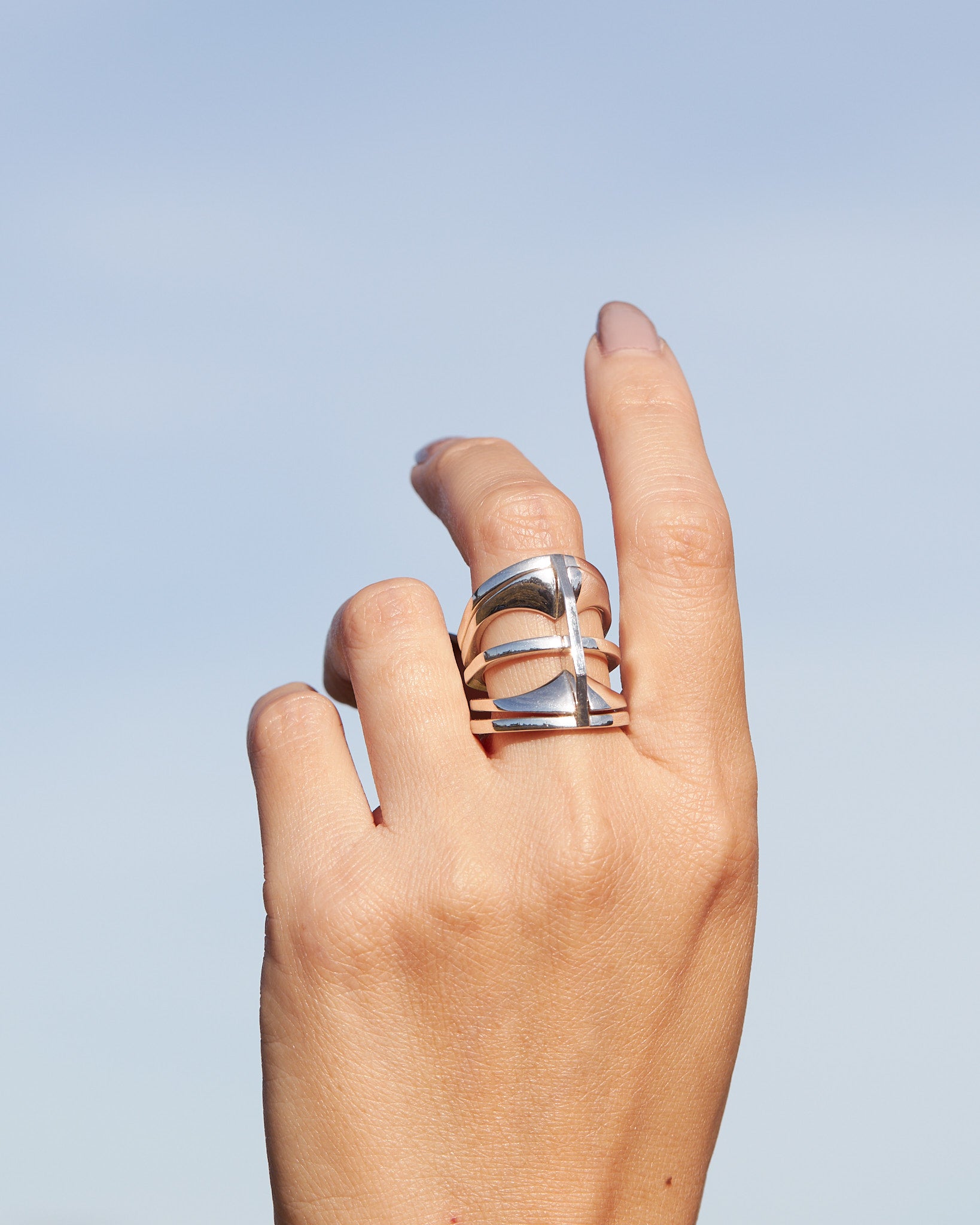 Close-up of the Kaleidoscope ring set worn on fingers against an outdoor background, emphasizing its stylish and contemporary look.