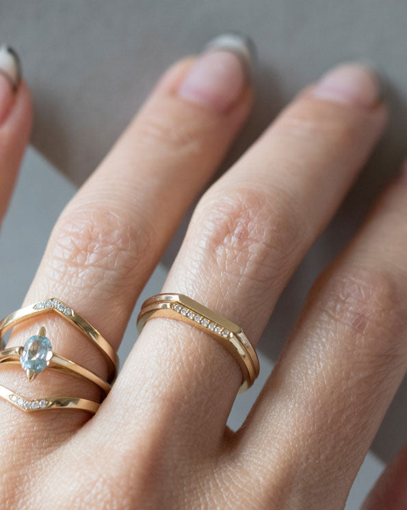 Minimalist Pavé Band showcased elegantly on a hand, featuring a delicate design with pavé set diamonds, layered with other minimalist rings, embodying luxury and sophistication.