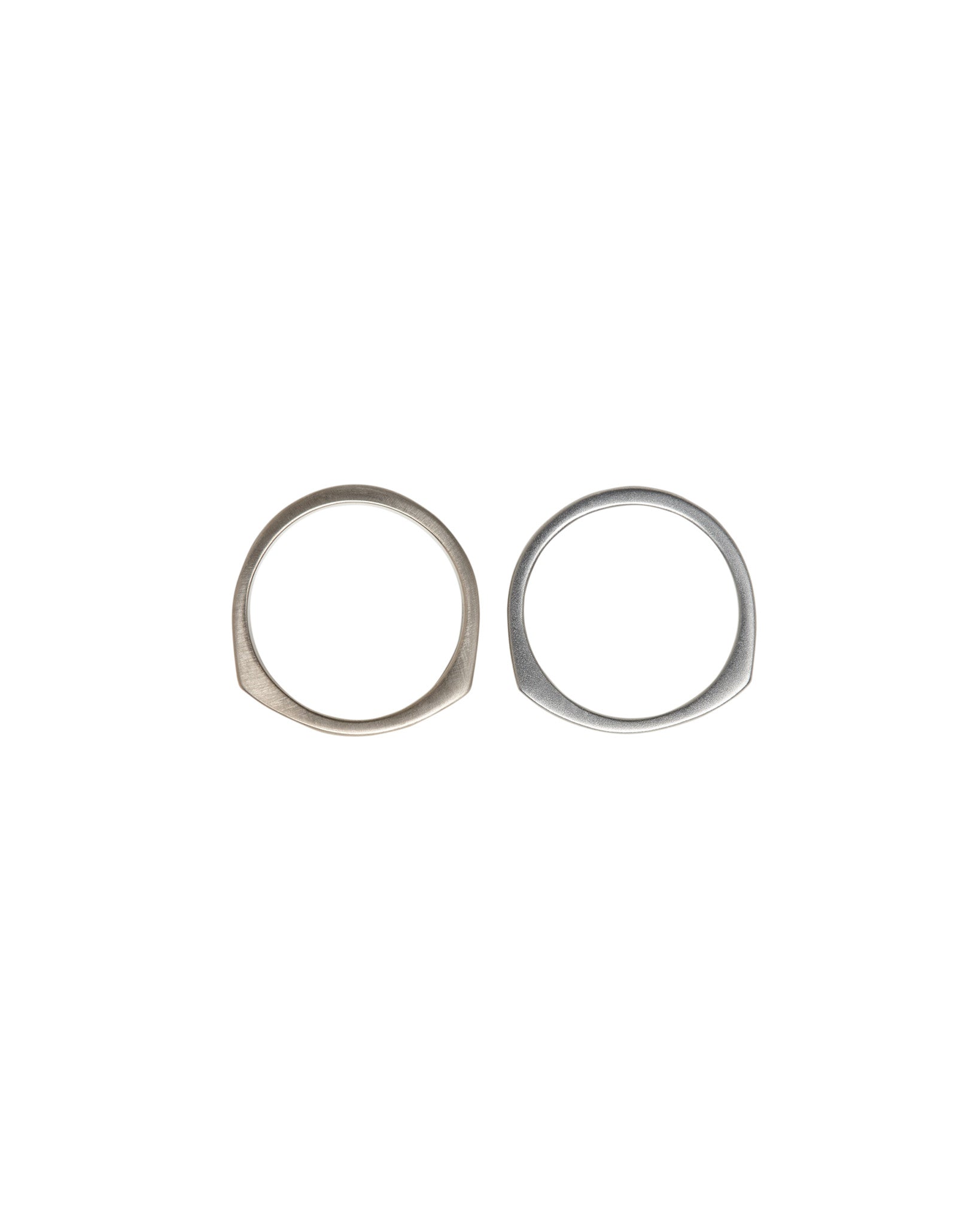 Objective Ring Set featuring a pair of elegantly designed rings, one in natural white gold and the other in solid platinum; showcasing a modern, matte finish.