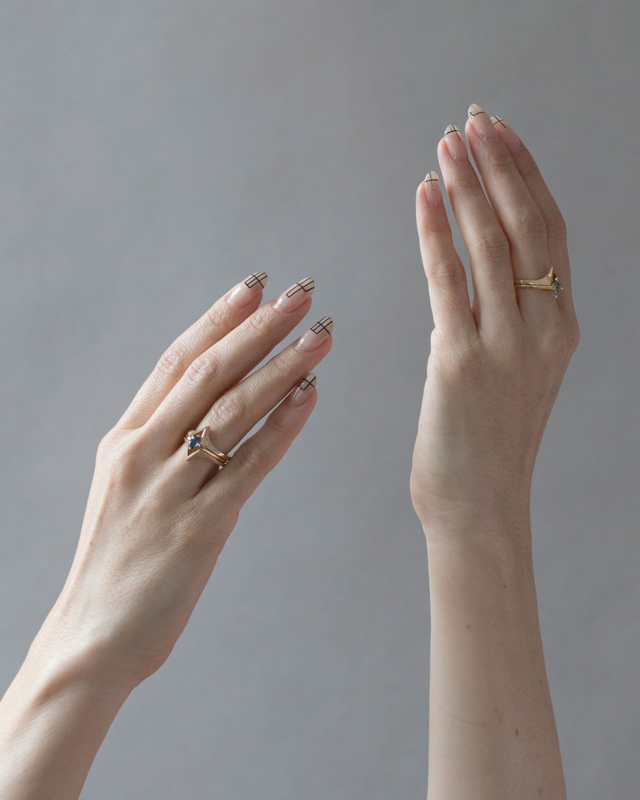 Minimalist Arc + Spire Pavé Ring Set worn by a model, showcasing the exquisite jewelry with manicured hands against a soft, neutral background.