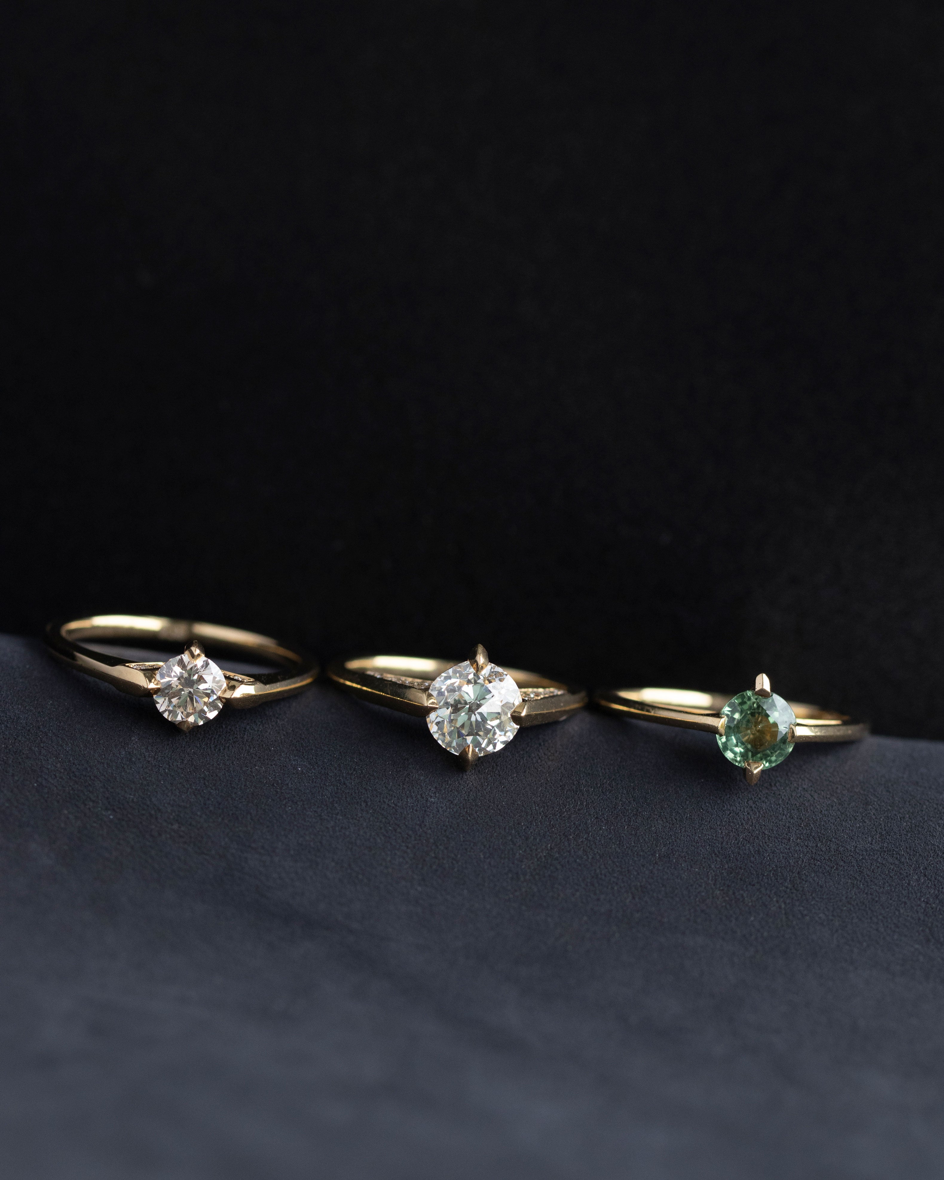 A beautifully designed minimalist gold ring shines on a soft surface, representing Bliss Lau's minimalist arc, minimalist rise, and minimalist pave aesthetics.