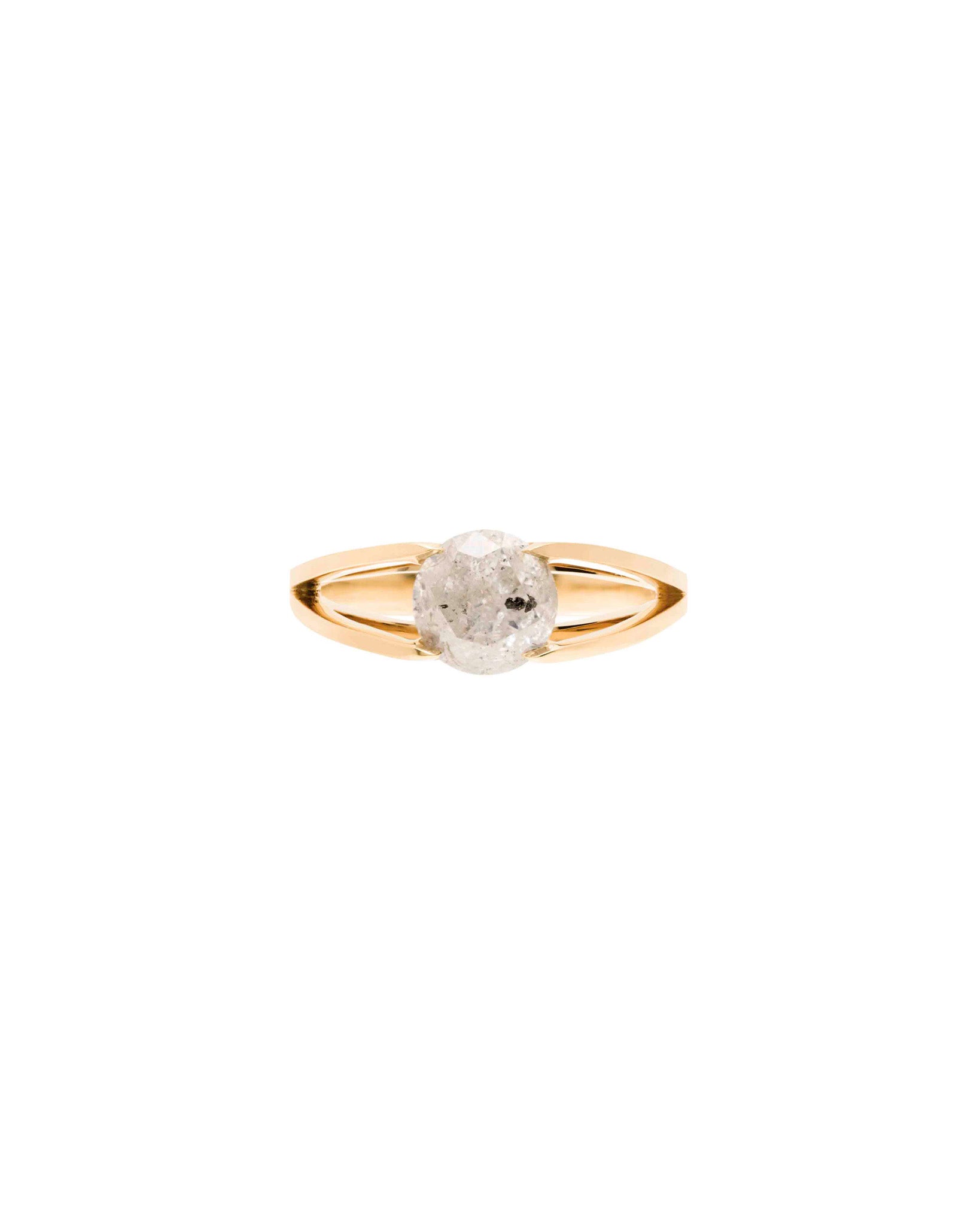 A gold band with a split shank that holds an icy diamond with some black specks