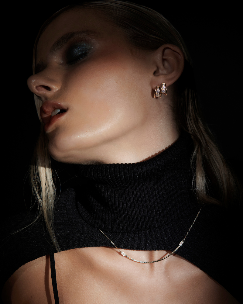 MOdel wearing Halo luna in a dark background. Bliss Lau Halo Luna Necklace is a combination of interlick chain and box chain with the box chain hanging perfectly centered and two lab diamond baguettes