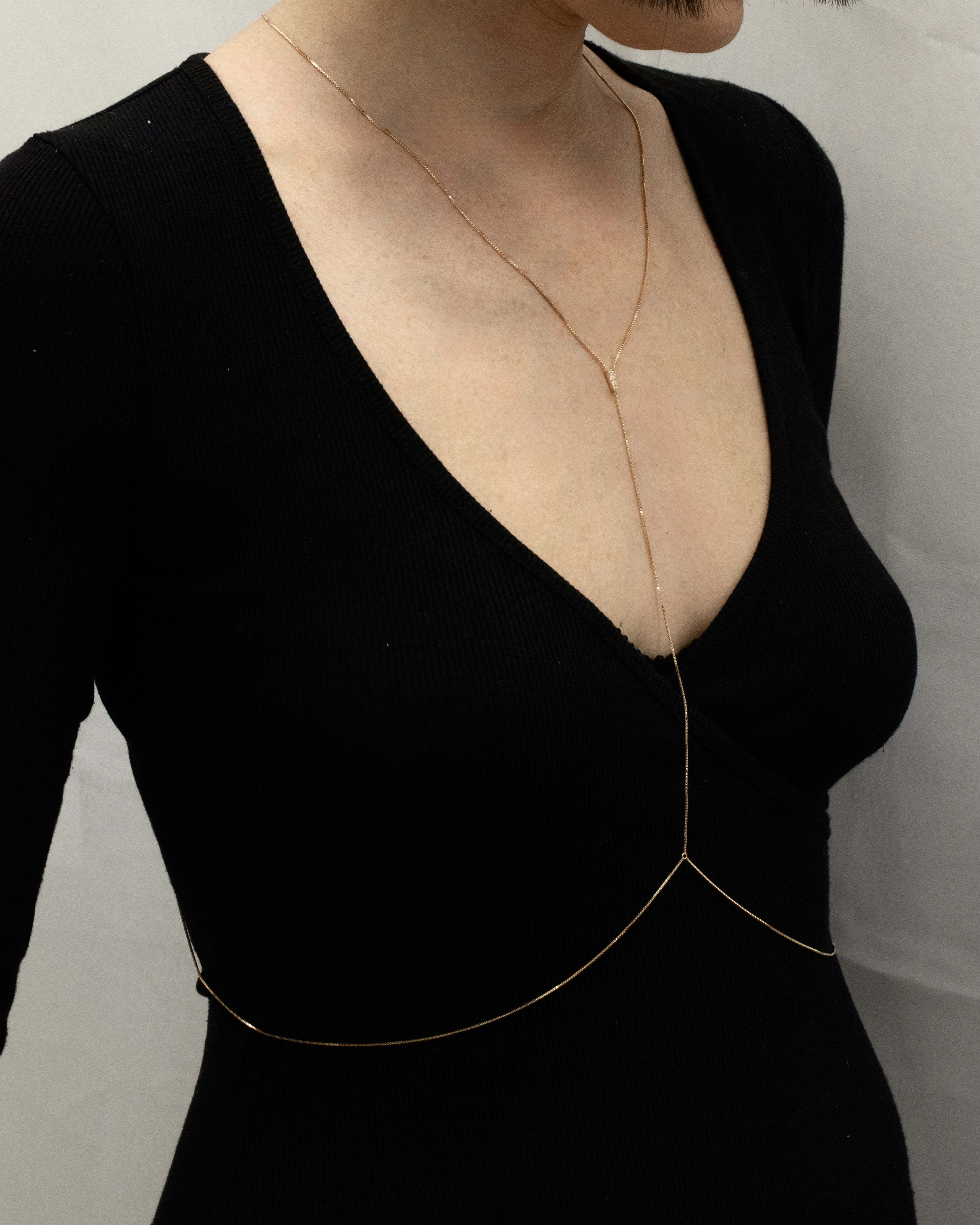 gold blink bodychain with thin chain worn on the body, front view right