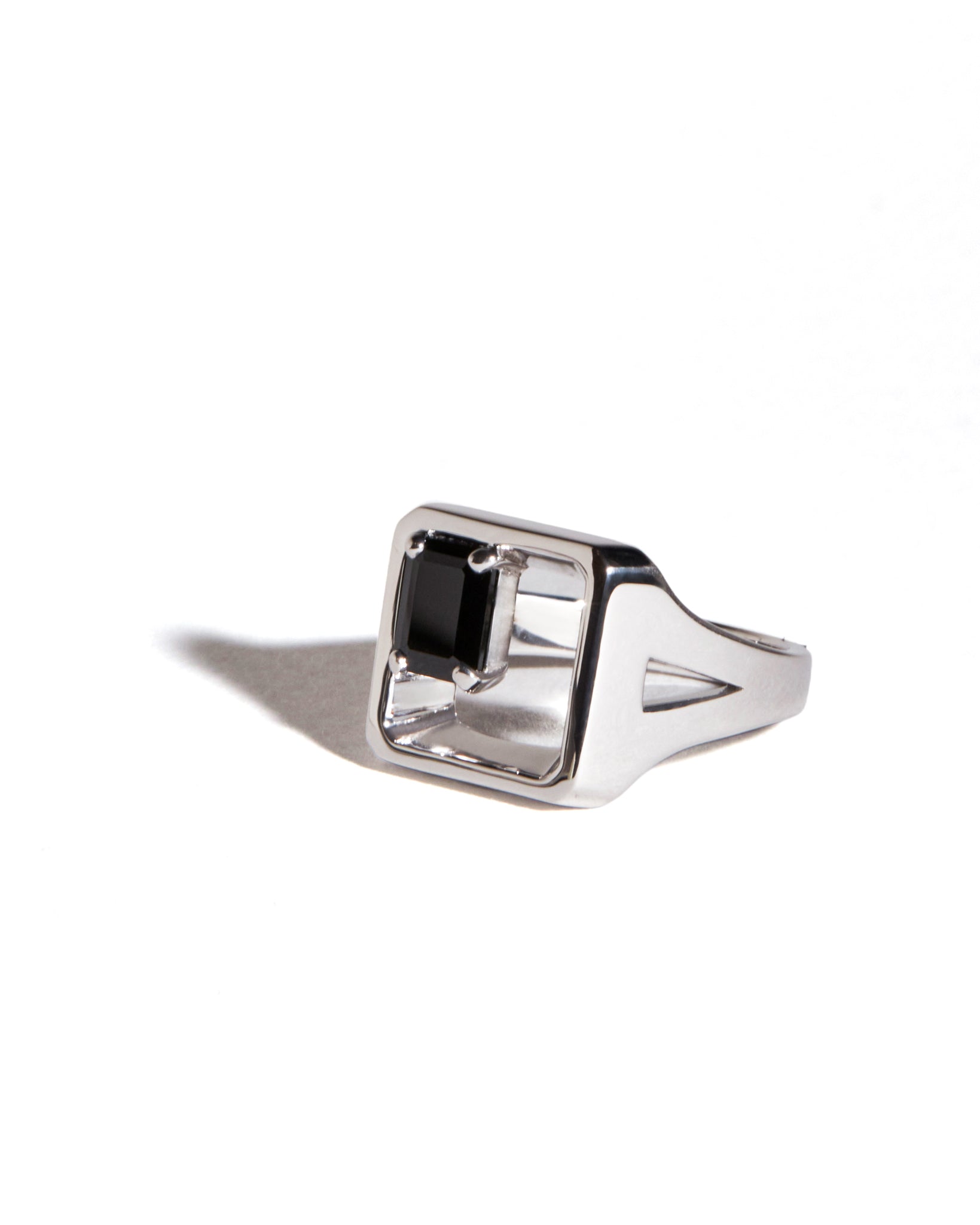 Silver signet ring with a black spinel gemstone on a white background