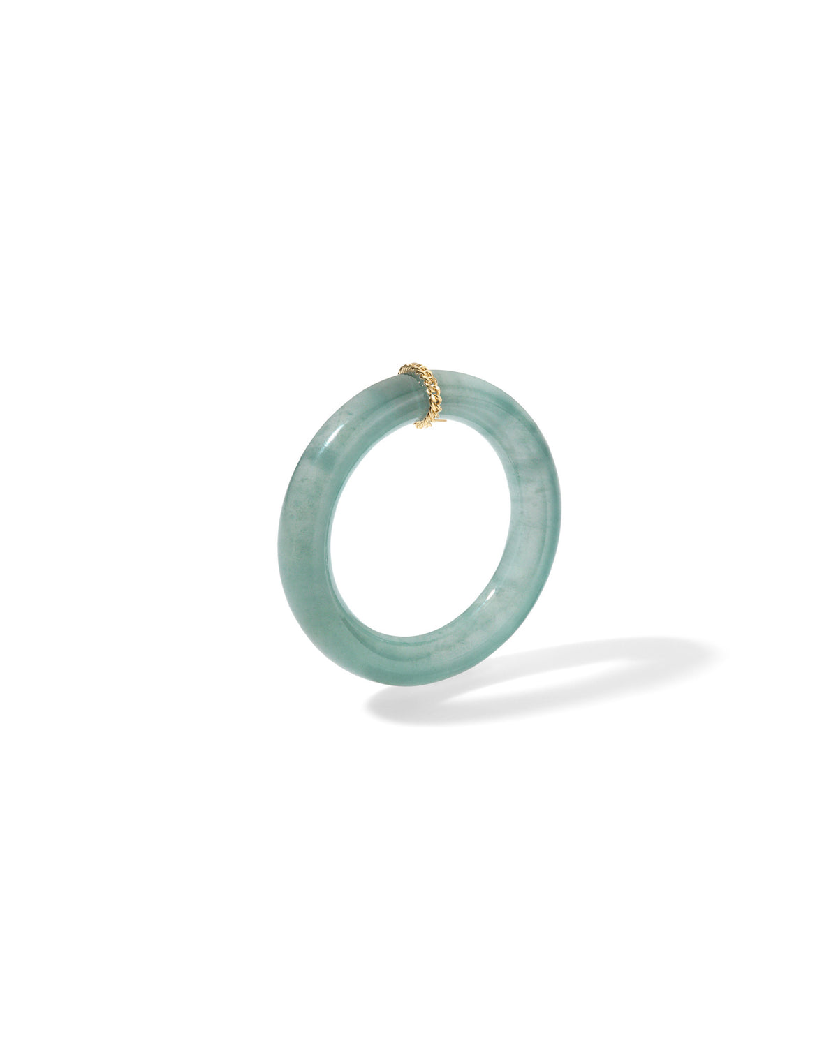 A Bliss Lau light green jade ring with a small gold accent bead at the top, shown floating against a solid white background.
