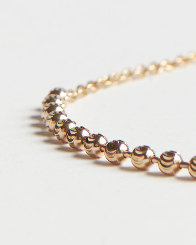 Close-up of The Vintage Halo Necklace featuring a delicate 10k yellow gold antique carved ball chain with lustrous spherical links, showcasing luxury craftsmanship.
