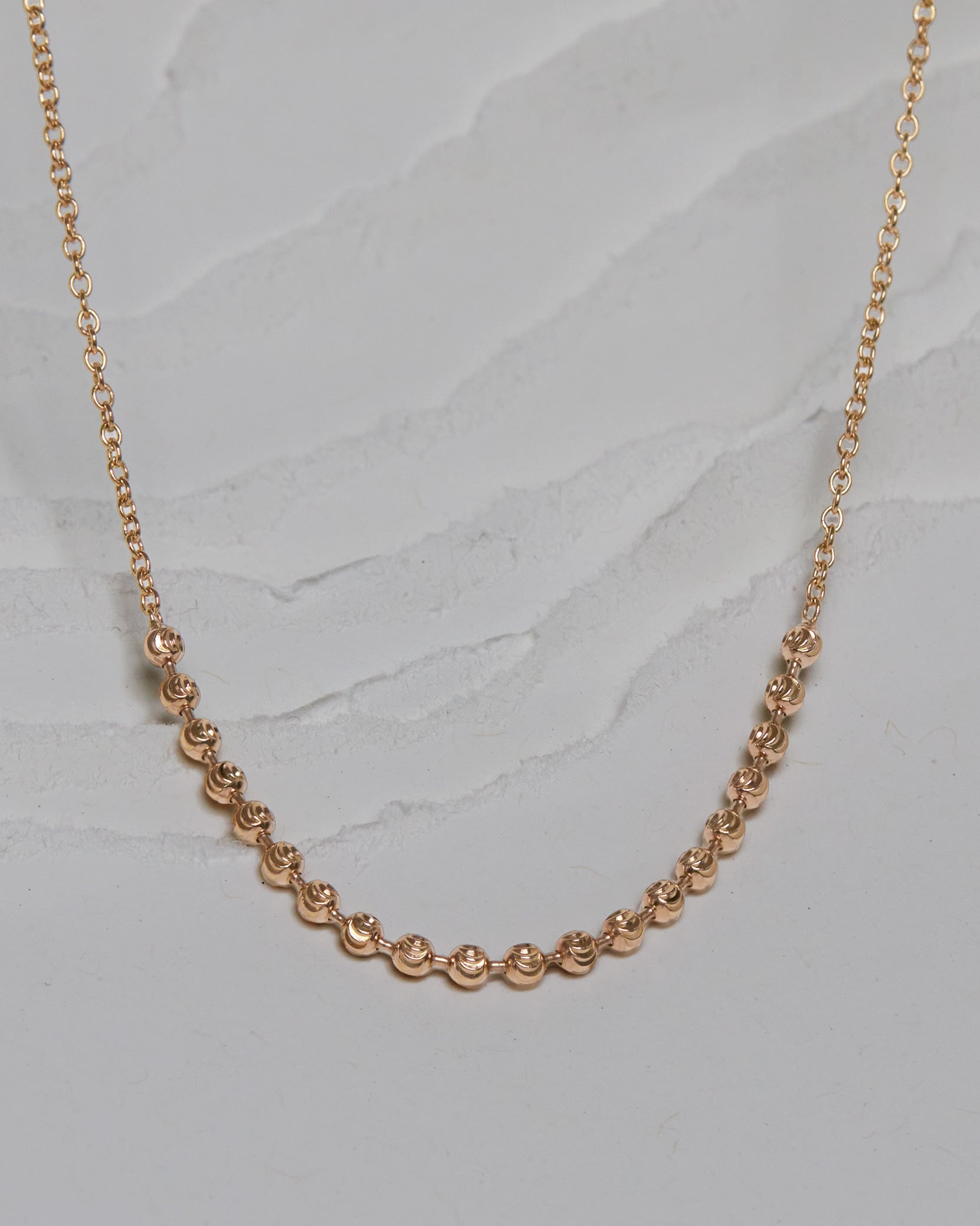 The Vintage Halo Necklace displayed elegantly, featuring an 18k yellow gold chain with a distinctive moon-phase inspired design, embodying refined luxury and limited edition exclusivity.