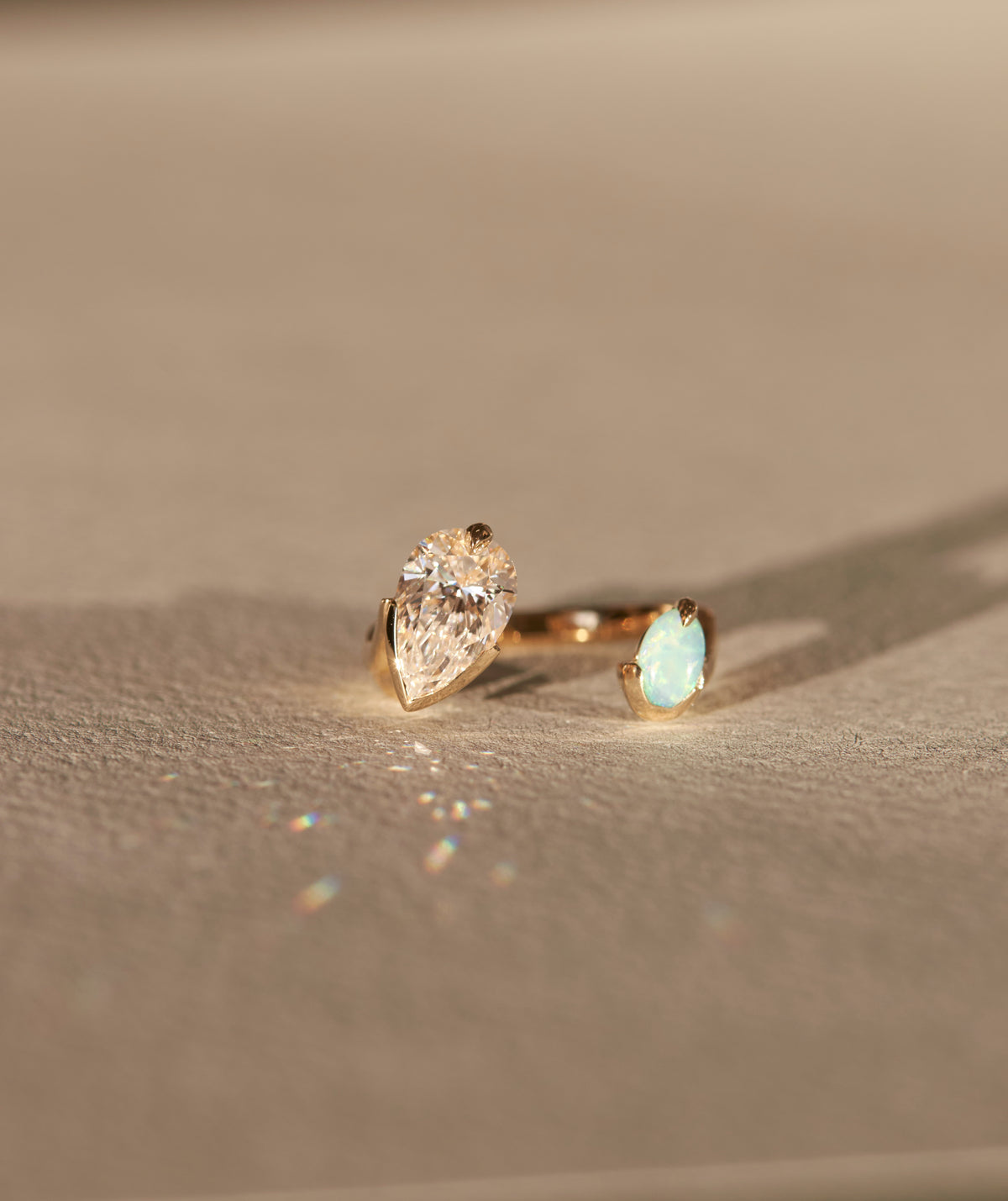 Intuitive Ring Sun Diamond by Bliss Lau featuring a pear shaped sun diamond and Australian white opal, handcrafted in luxurious 14k Fairmined Gold, showcasing stunning design elements and vibrant gemstones.