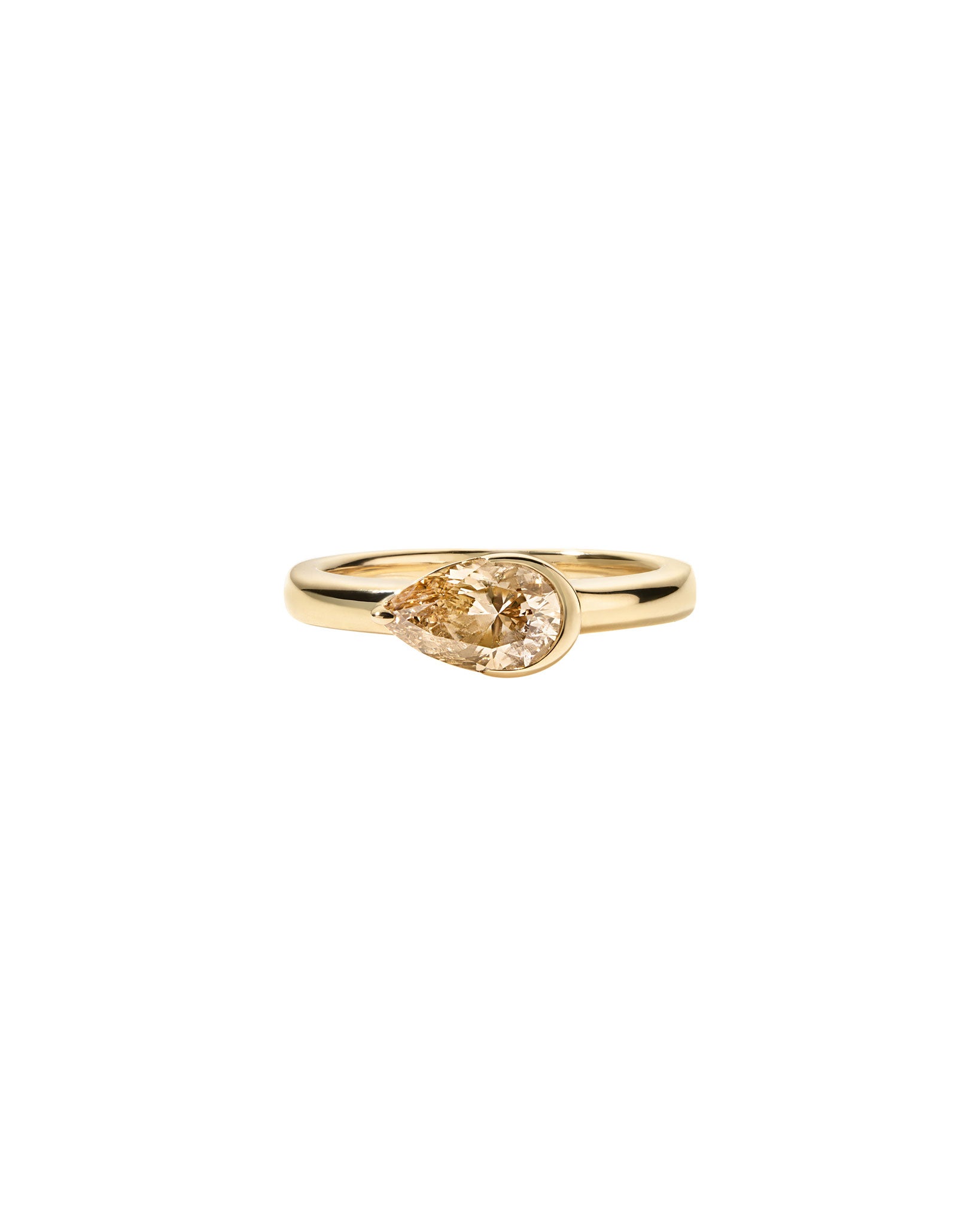 Gold ring with a natural pear diamond on a white background