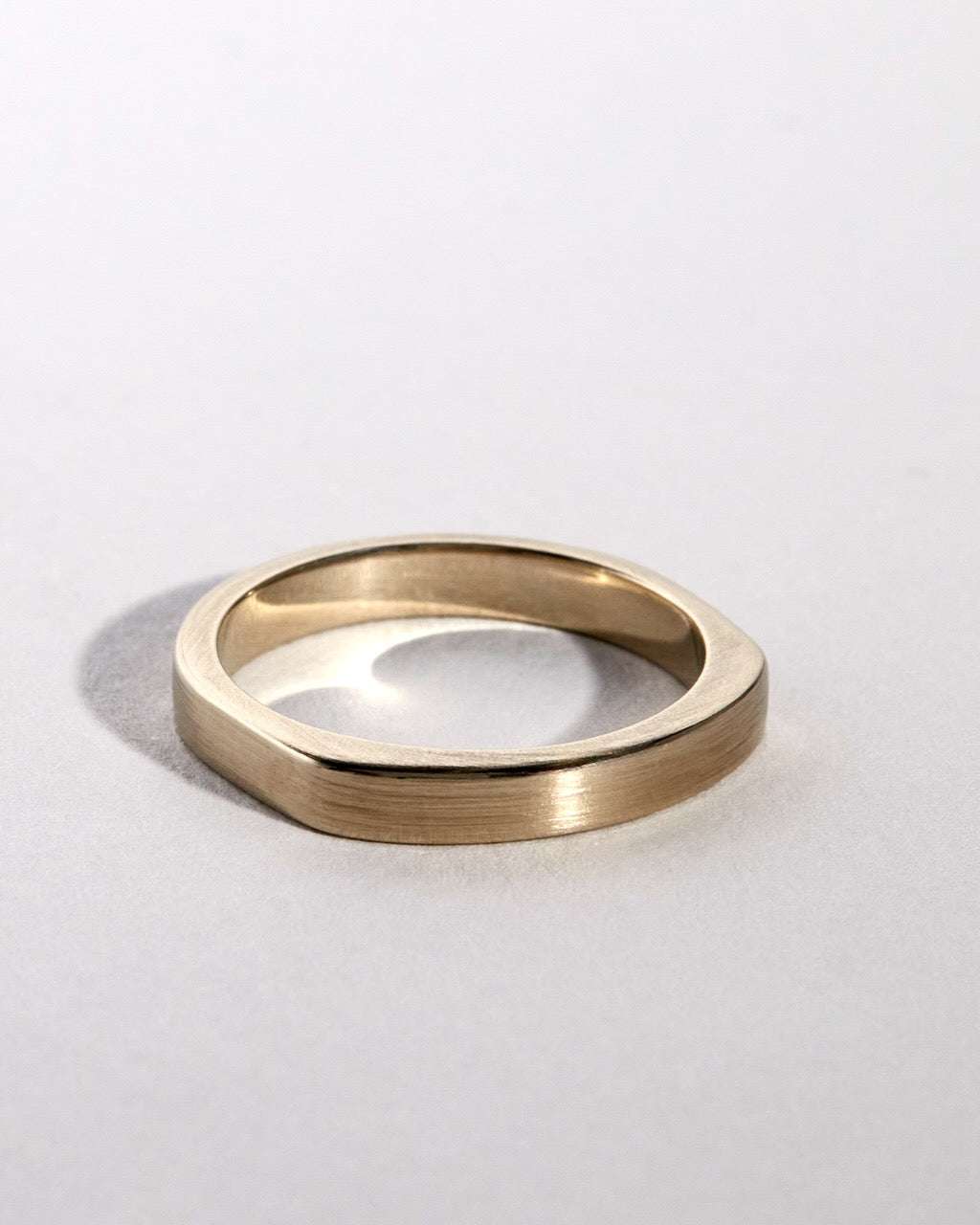 Gold ring on a light gray background
