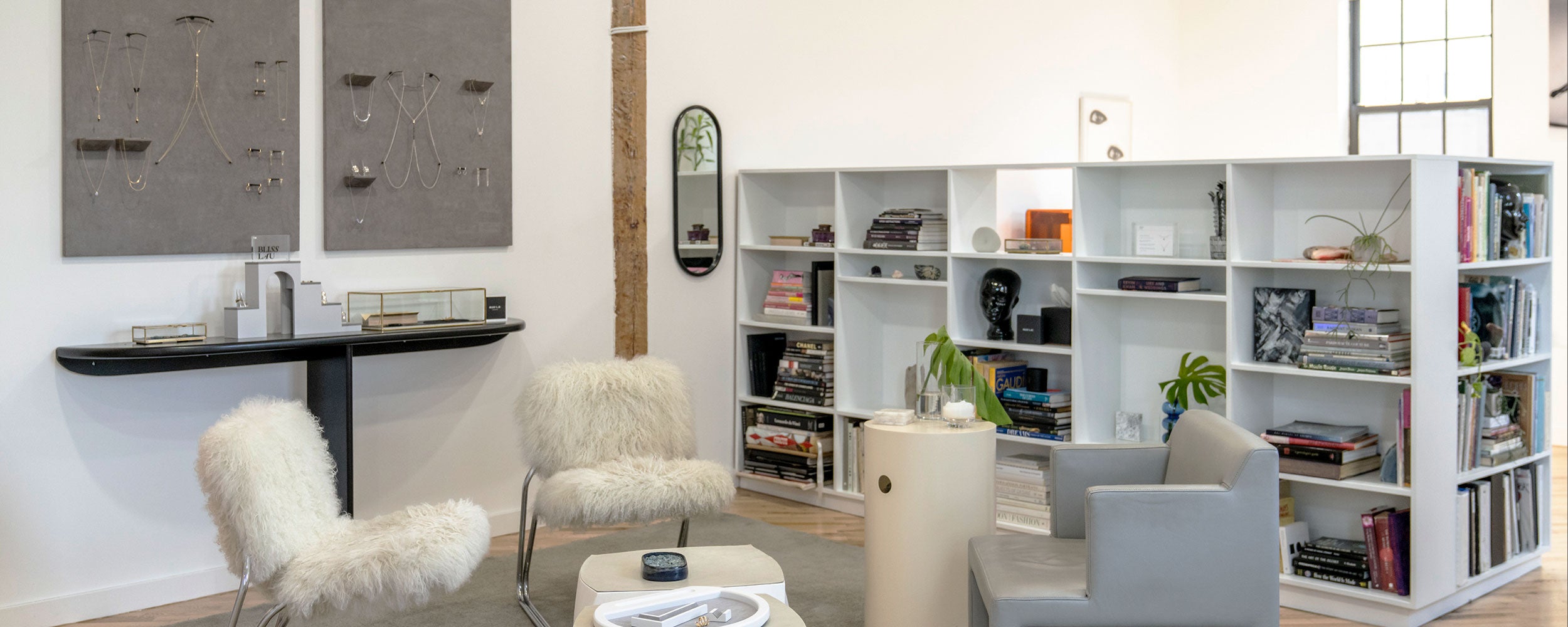 Modern jewelry studio of Bliss Lau with white furniture, books, jewelry and decorative items.