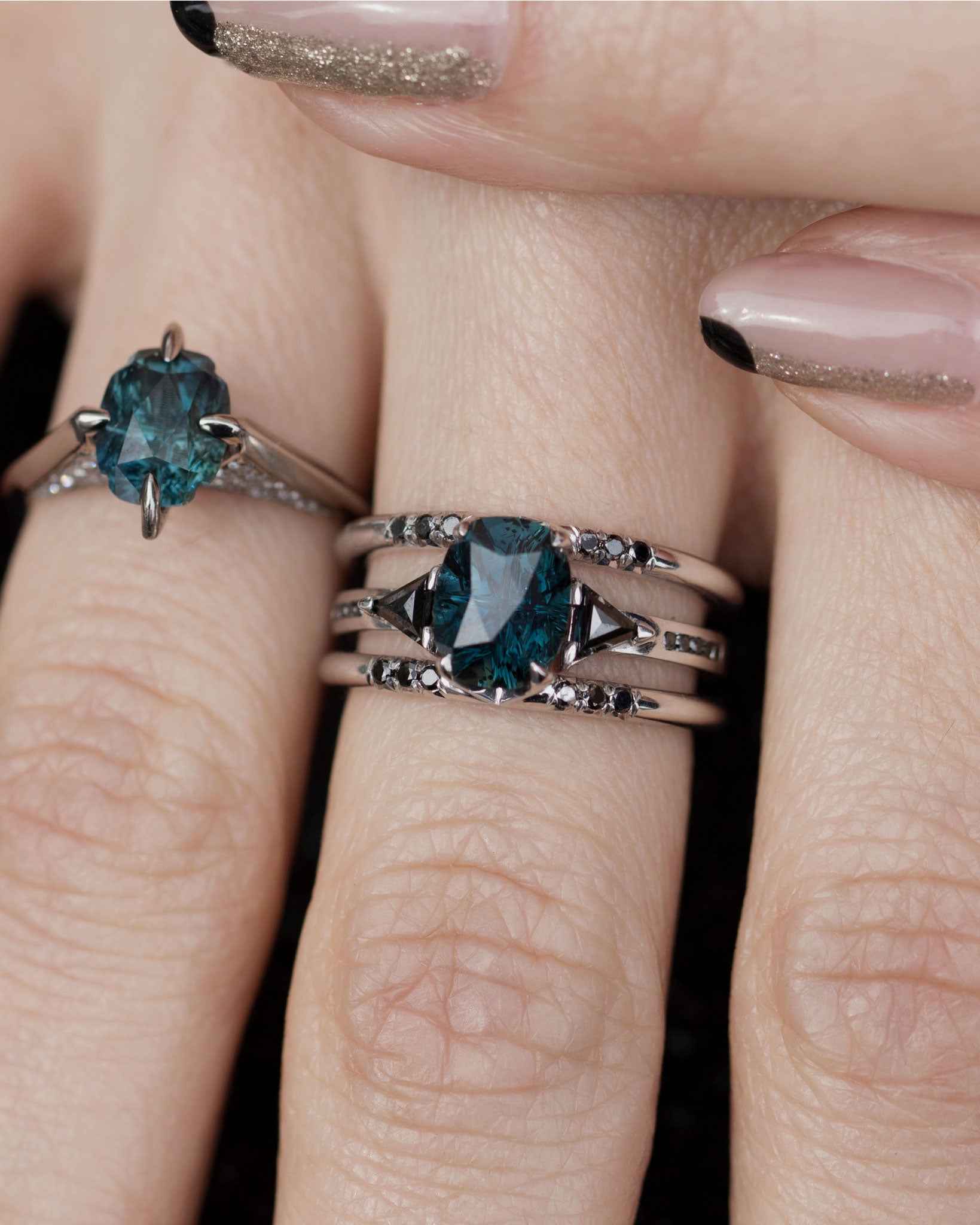 Close up of Bliss Lau Illuminate ring with magnetic band and minimalist rise ring as well on hand. 