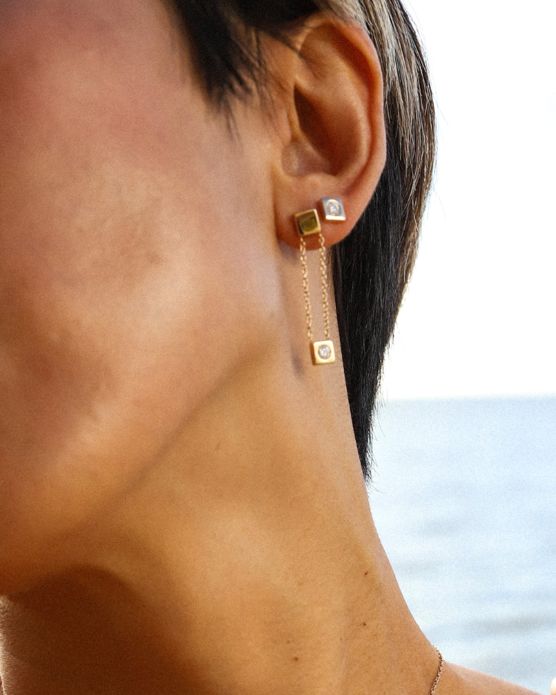 Rain stud and rain earring paired together. A perfect circle diamond embedded within a solid gold square.