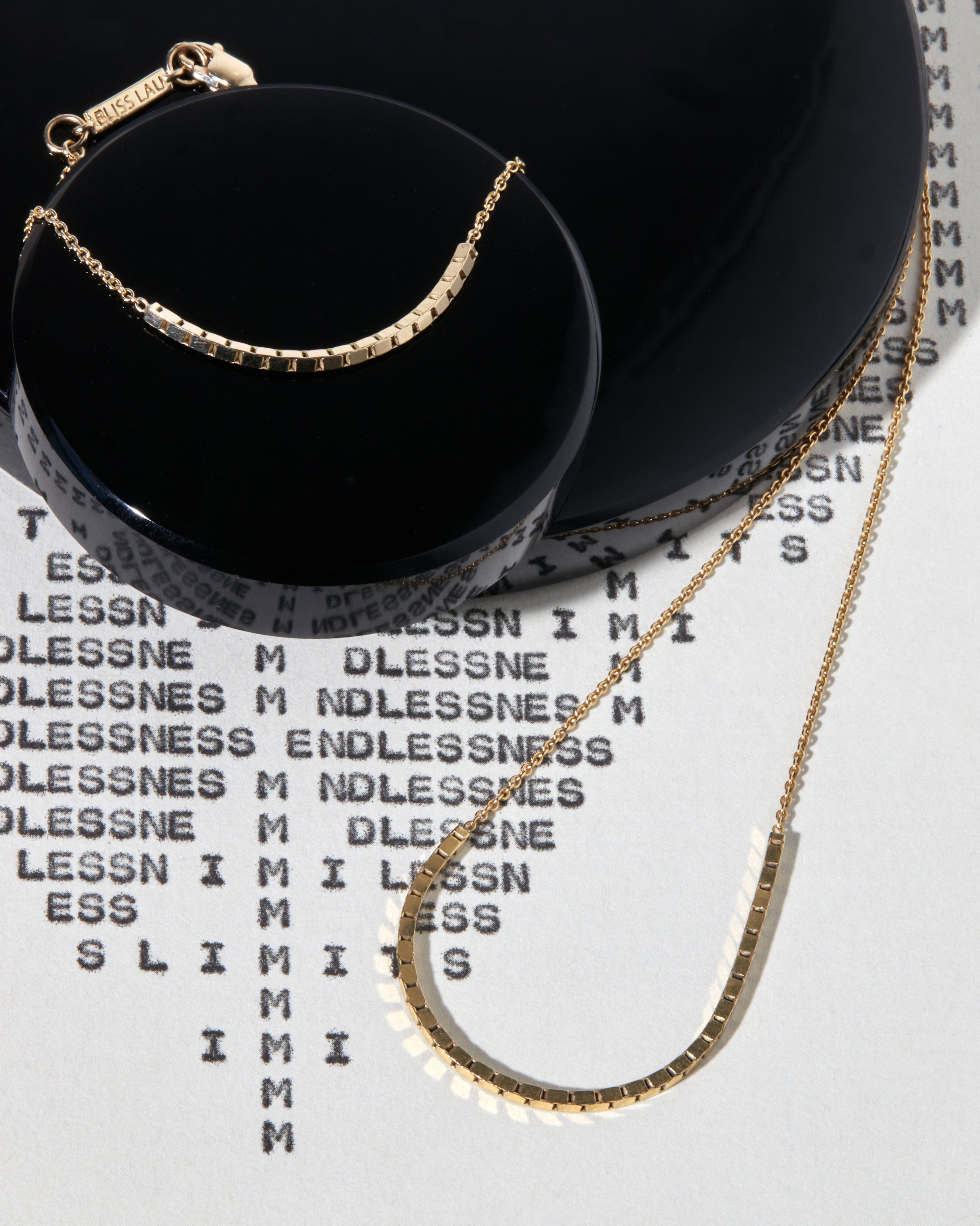 Halo Necklace alongside a bracelet on a sleek surface, illustrating its refined style and the elegance of golden accents.